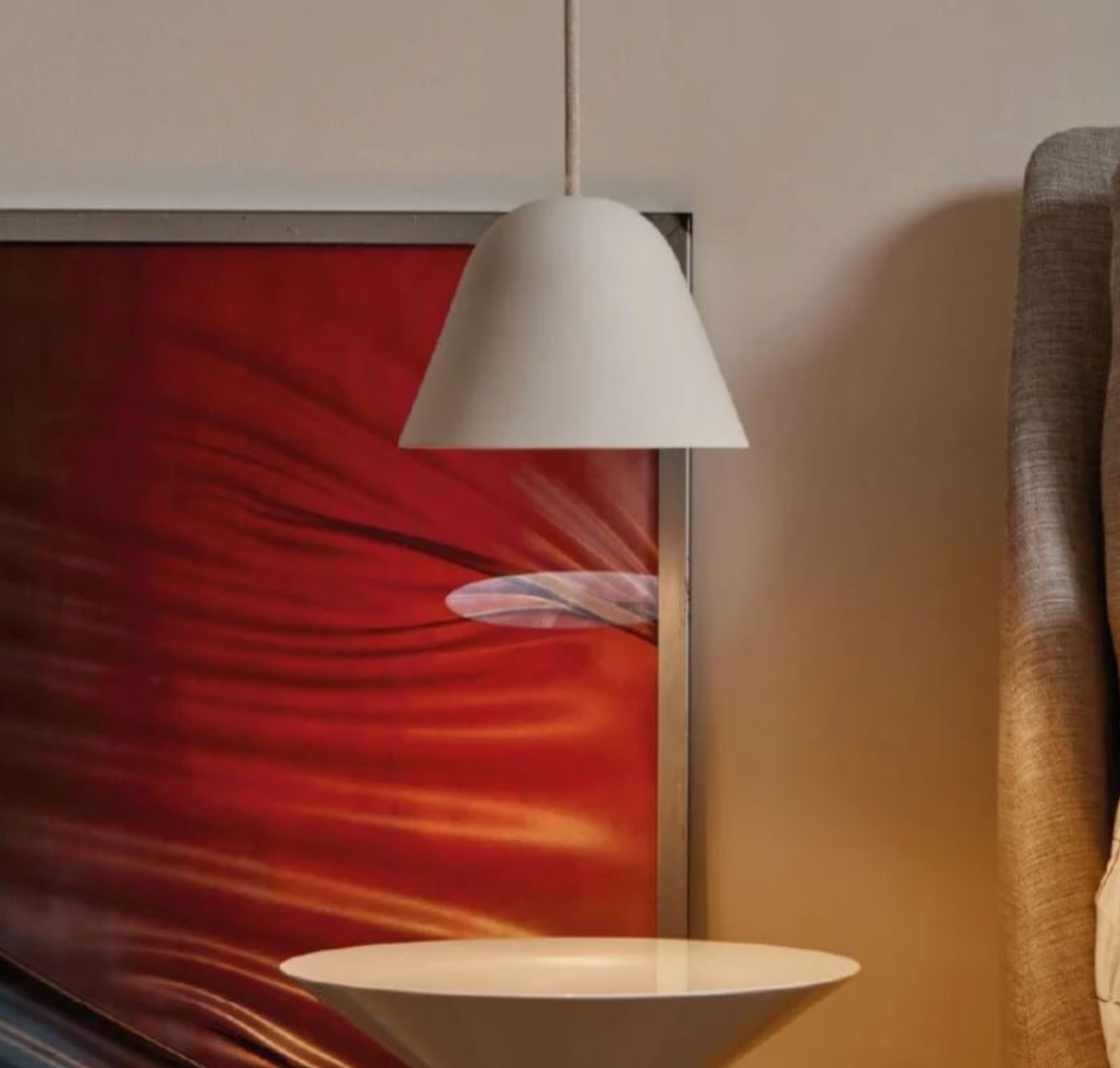 White clay pendant lamp hanging in a room with abstract art on the wall.