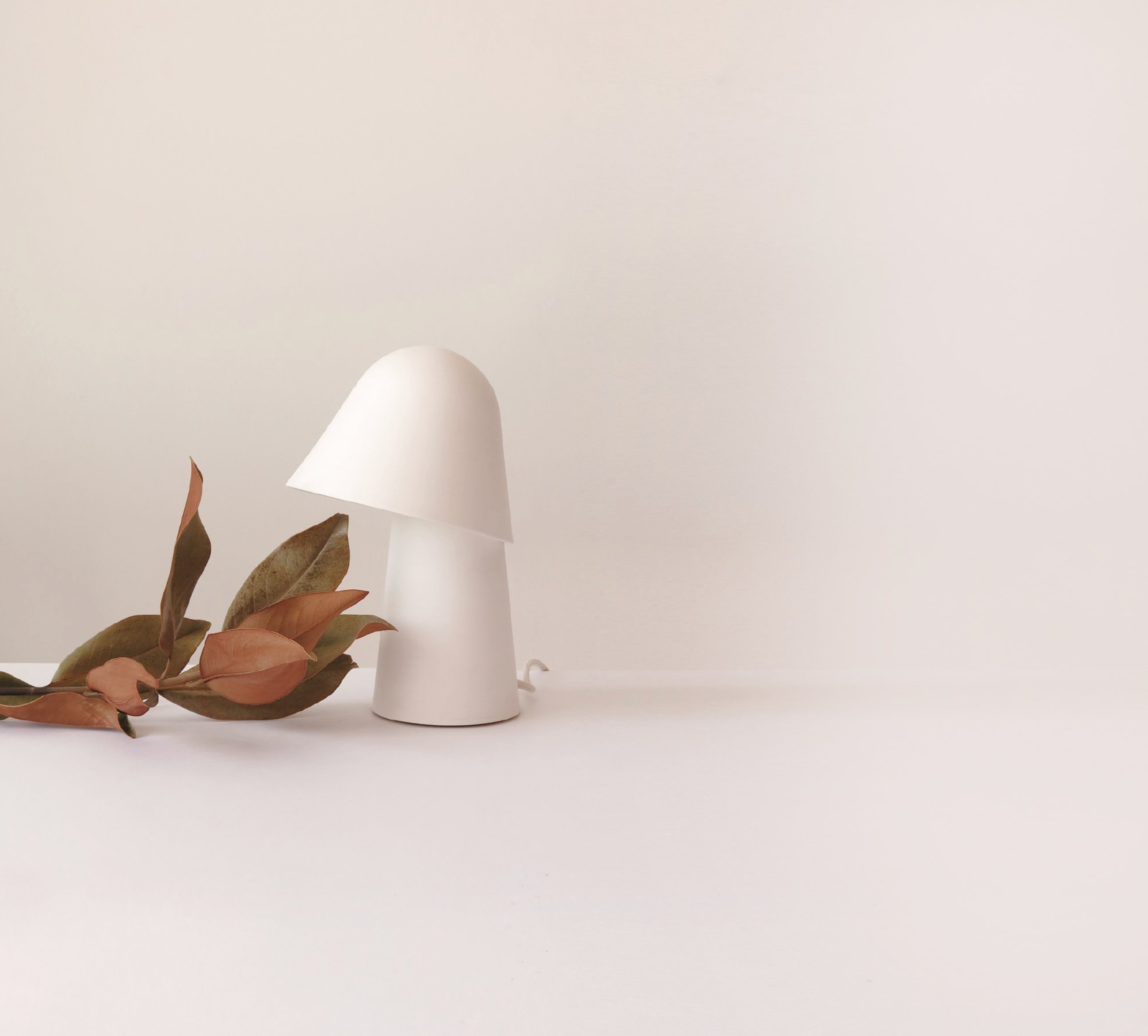 White lamp on a white surface with a minimal background