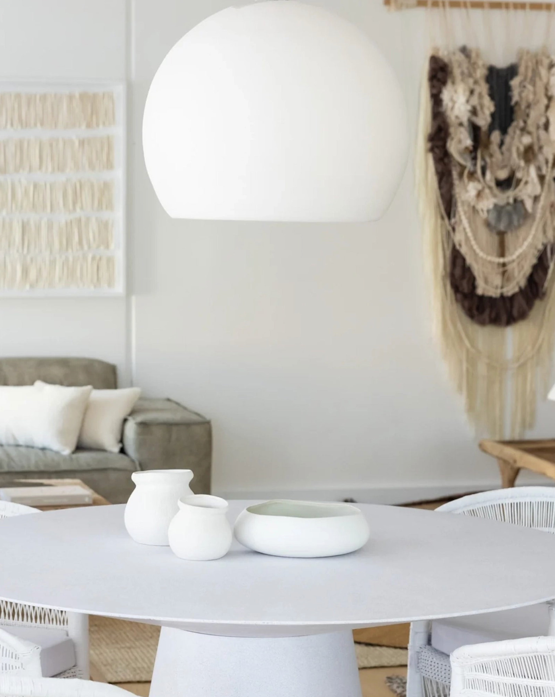 Modern living room with a white table, chairs, and decorative items.