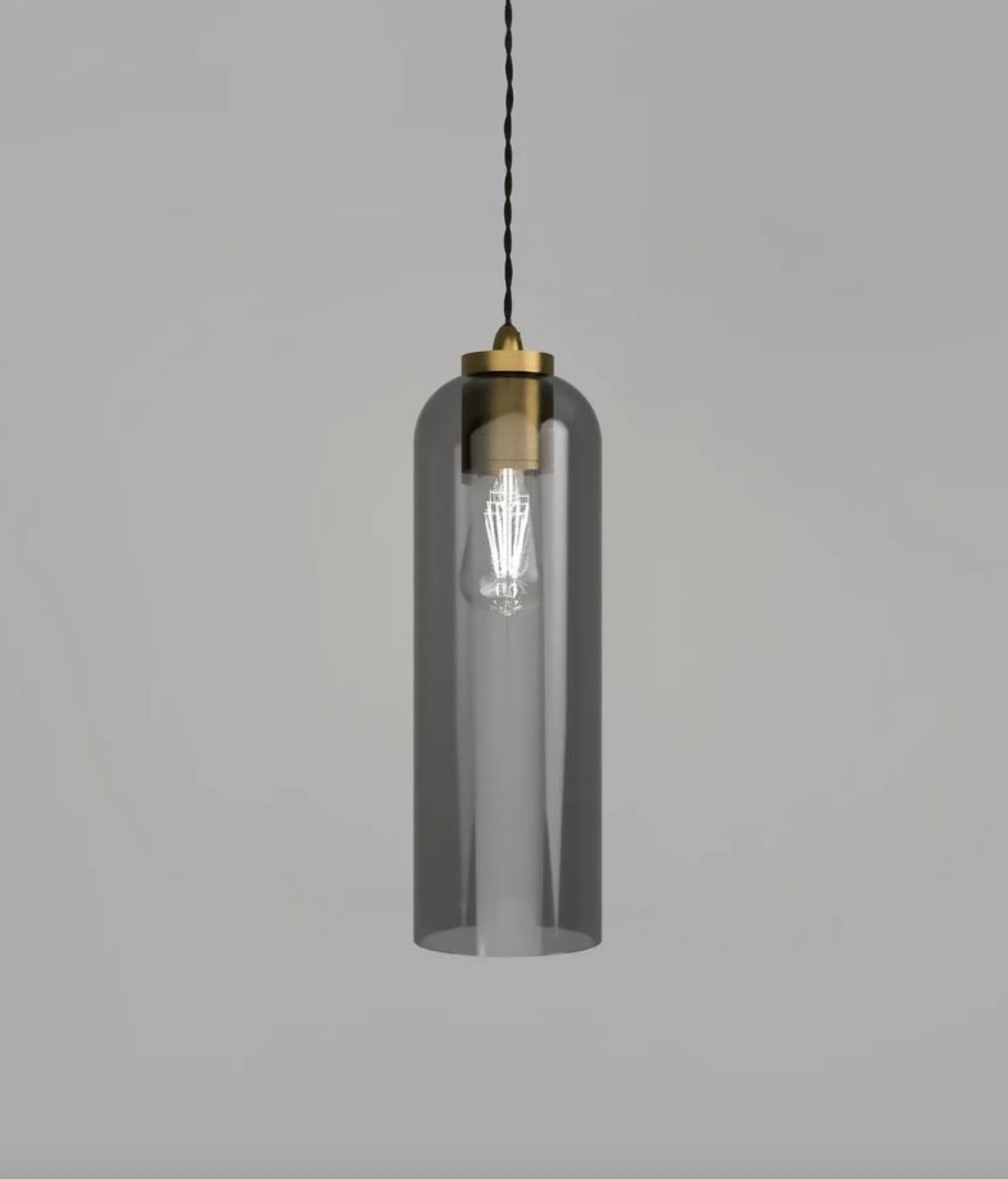 Pendant light with clear glass shade and brass fixture on a grey background