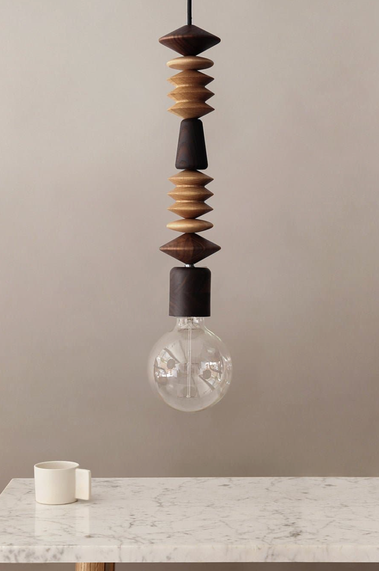 Decorative pendant light with wooden beads on a neutral background