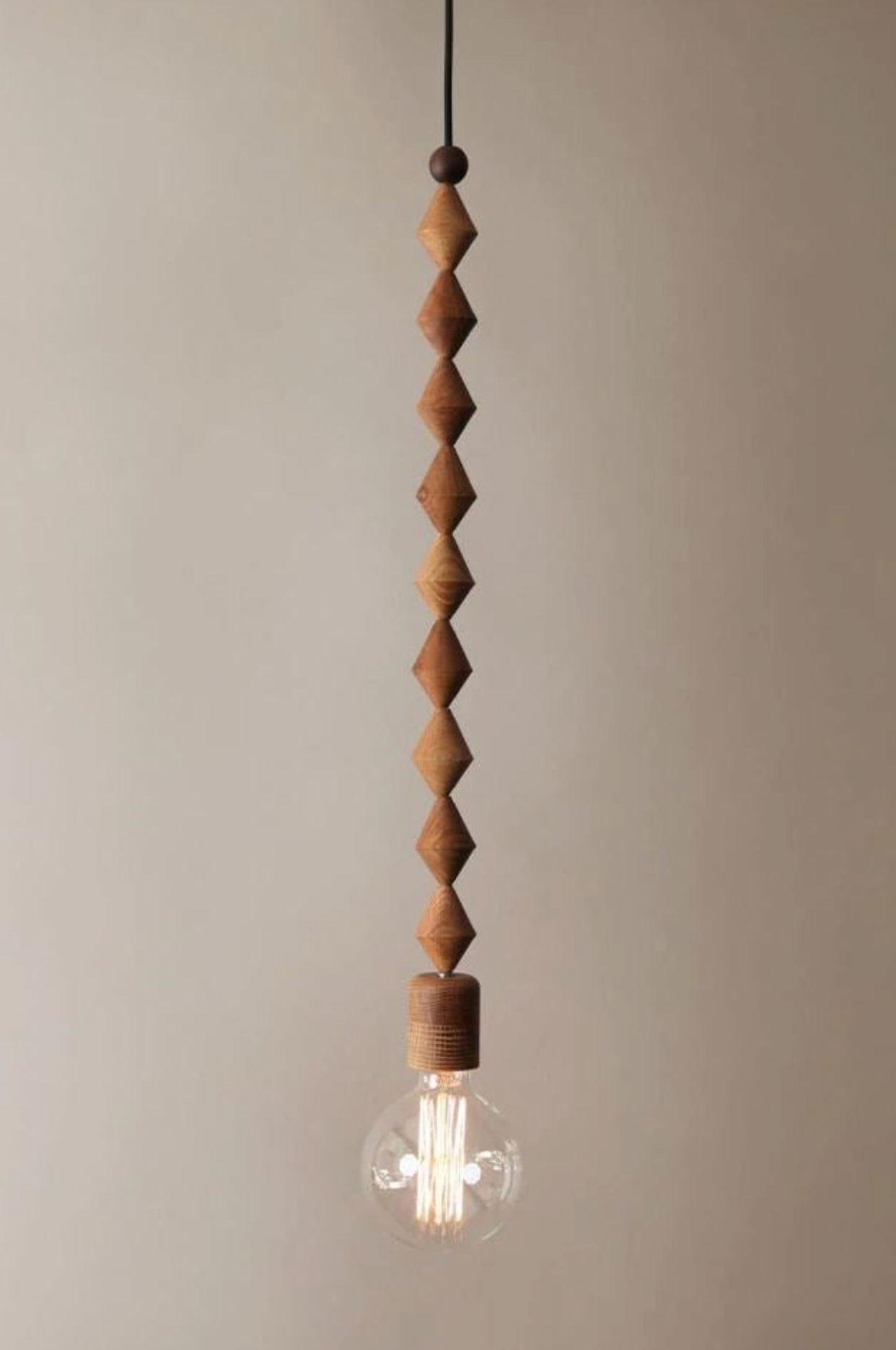 Wooden pendant light with a clear bulb on a beige background