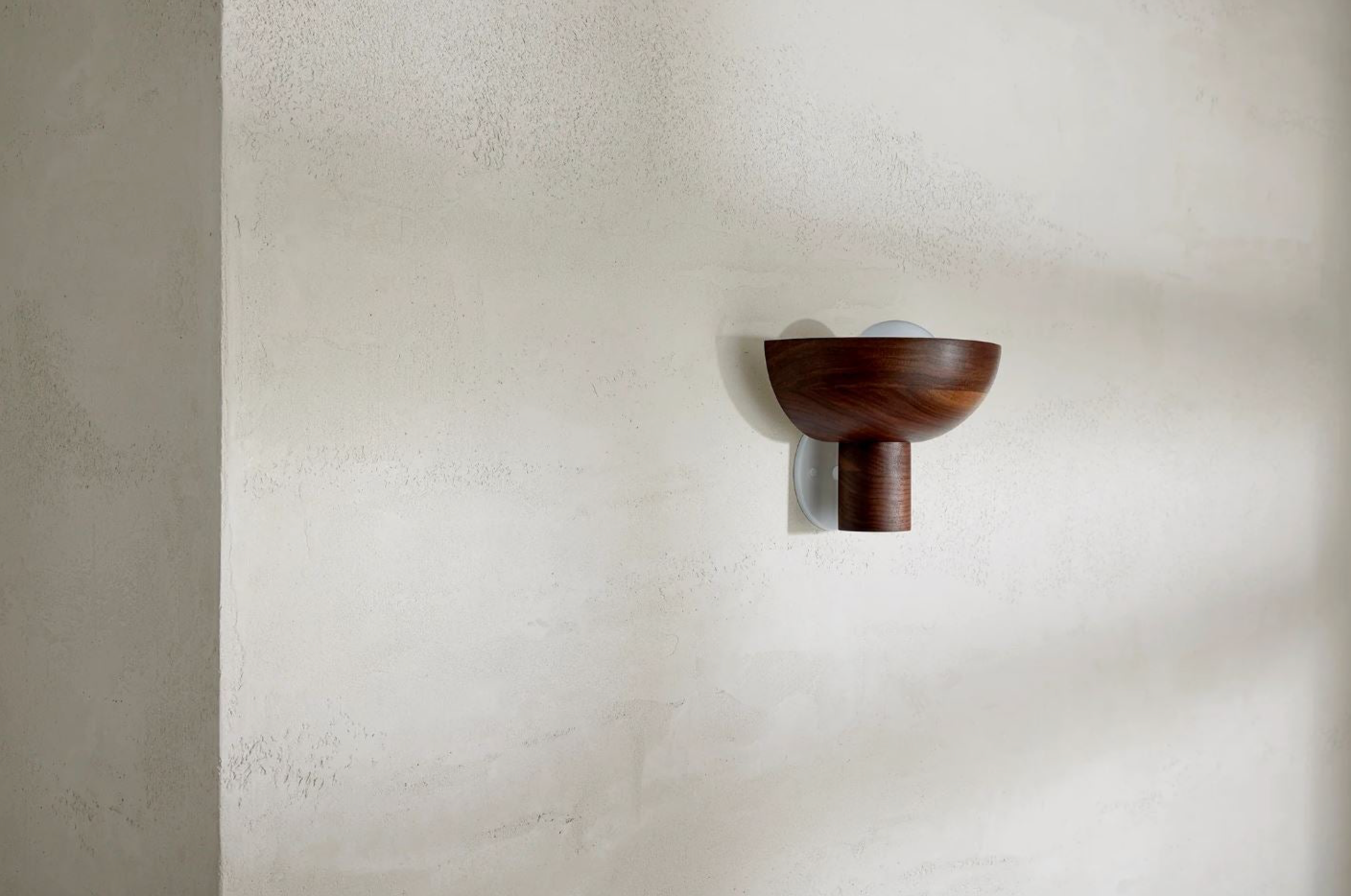 Wooden wall sconce on a textured beige wall