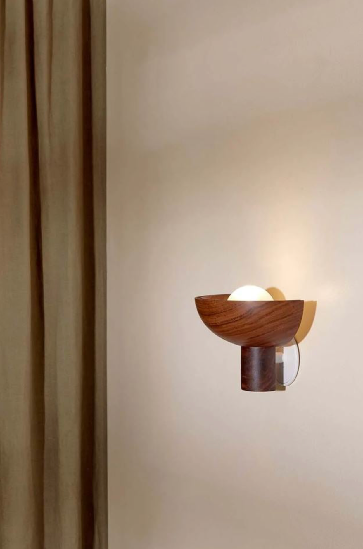 Modern wall sconce with wooden design on a neutral wall.