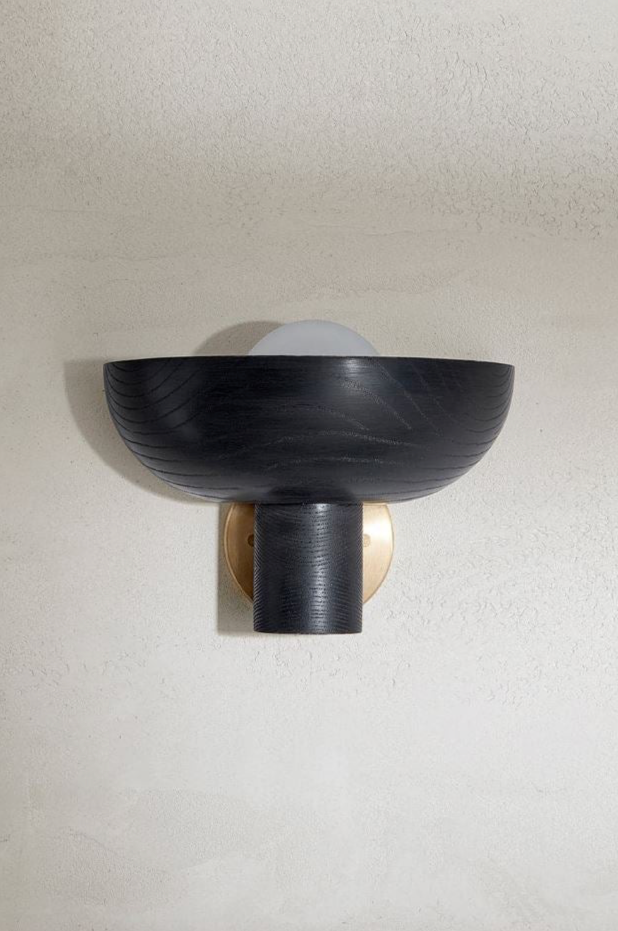 Black wall-mounted light fixture on a plain wall