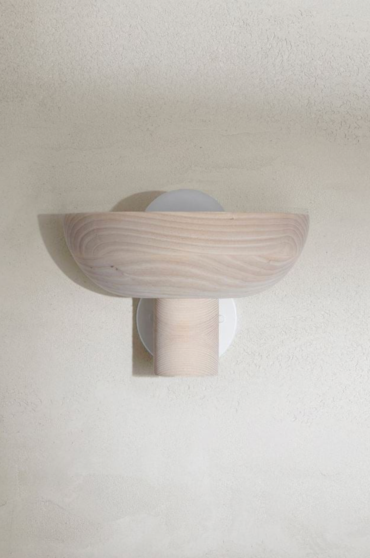 Wall-mounted light fixture with a wooden finish on a white wall