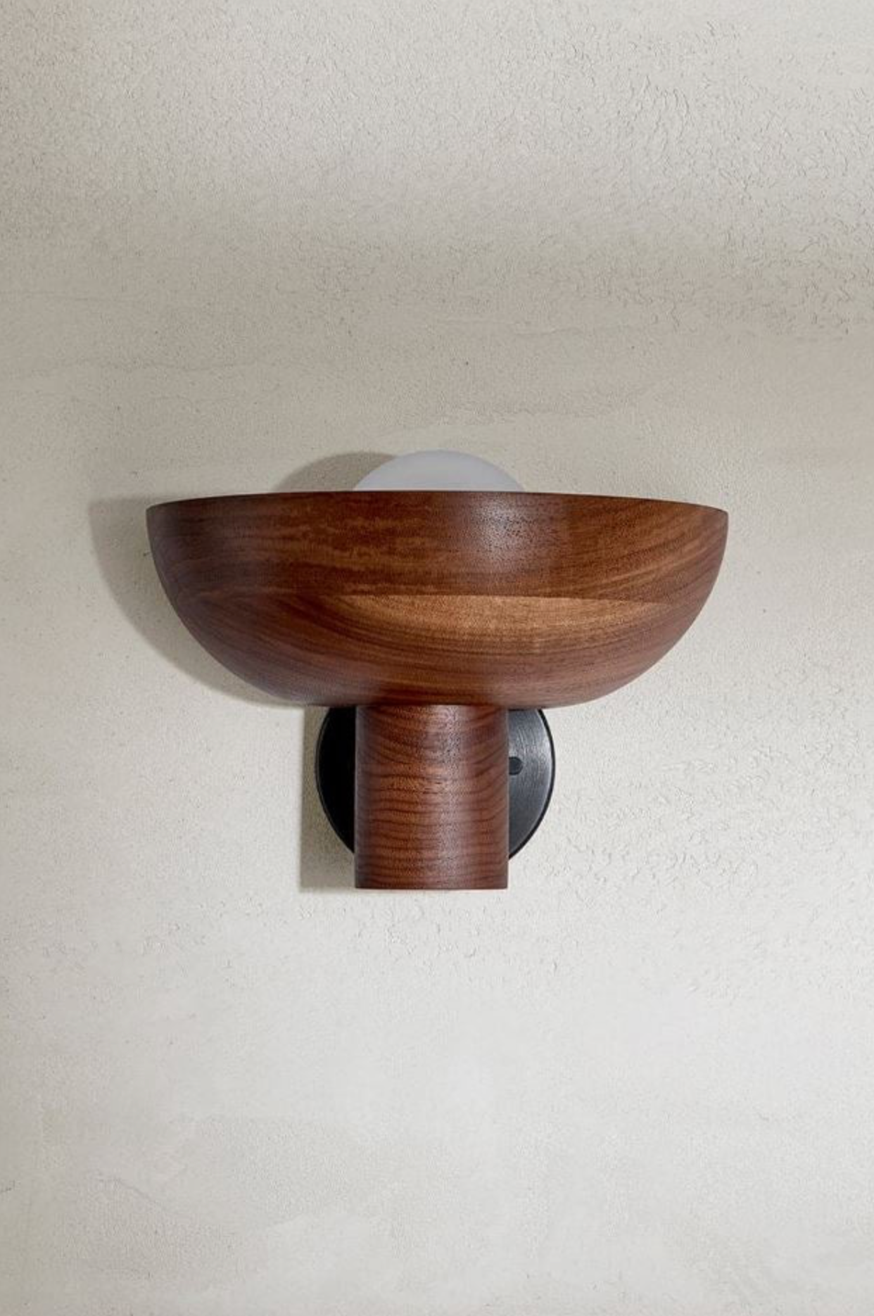 Wooden wall sconce mounted on a plain wall