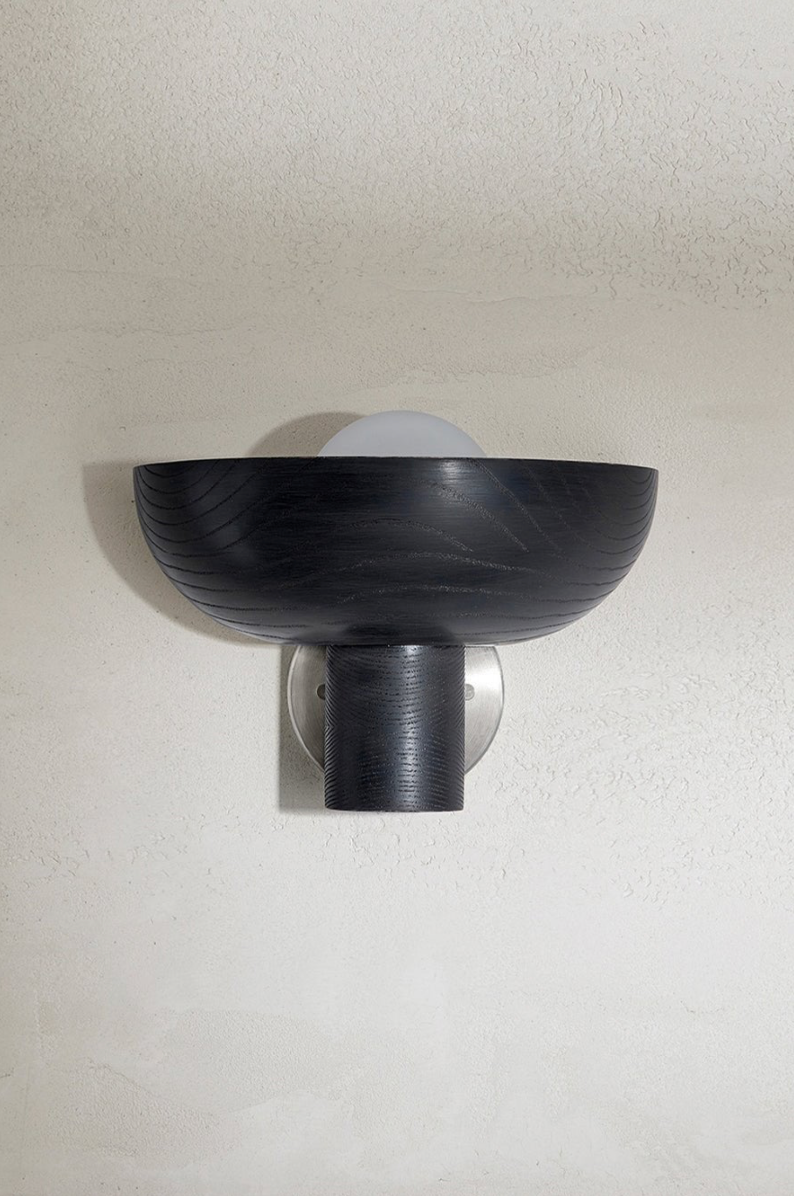 Black wall-mounted light fixture on a white wall
