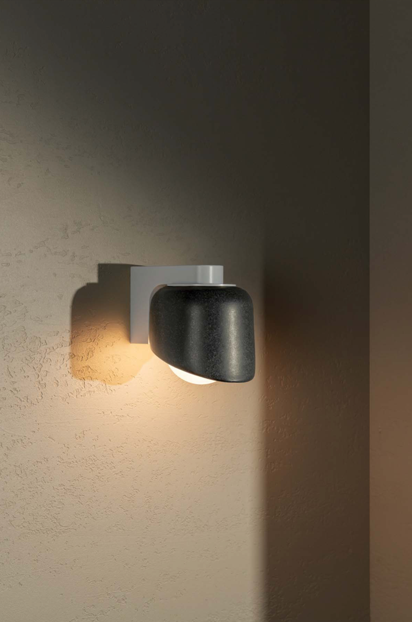 Modern wall-mounted light fixture on a textured wall