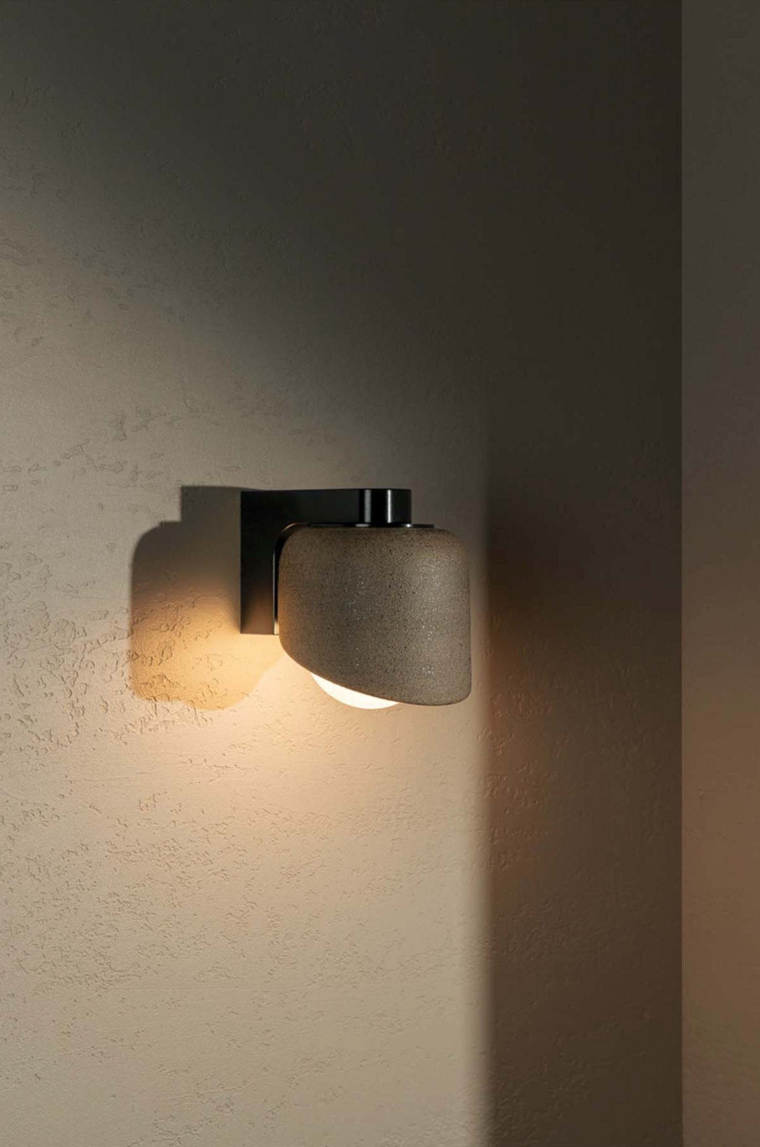 Modern wall-mounted light fixture on a textured wall