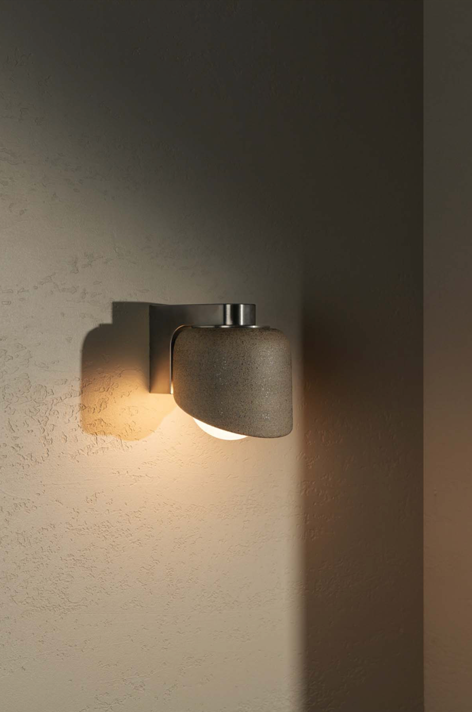 Modern wall-mounted light fixture on a textured wall
