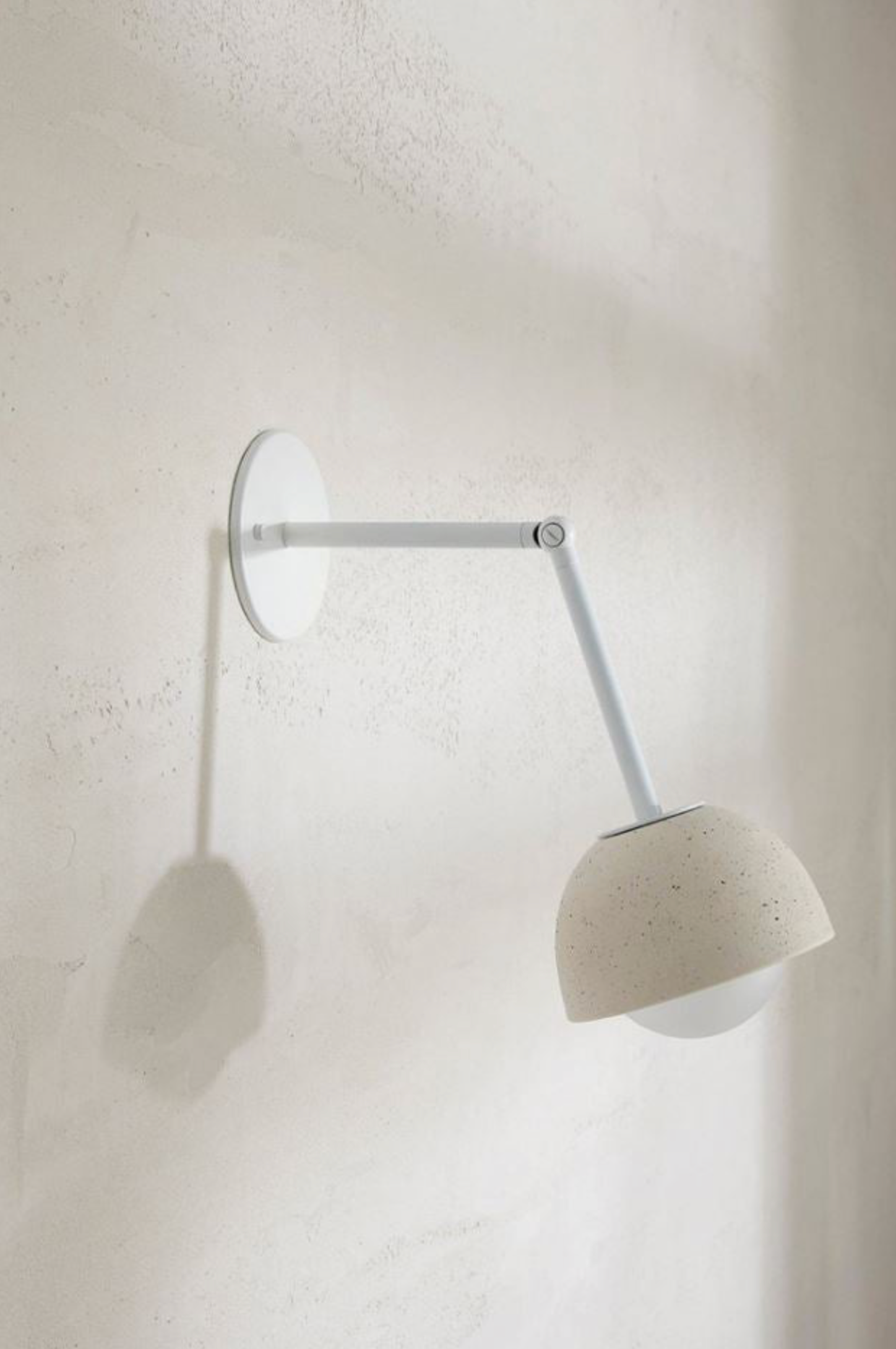 Wall-mounted lamp with a ceramic shade on a white wall