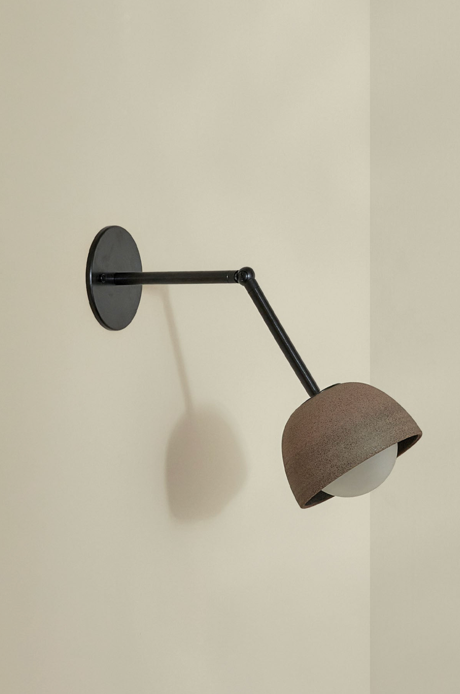 Wall-mounted lamp with a brown shade on a beige wall
