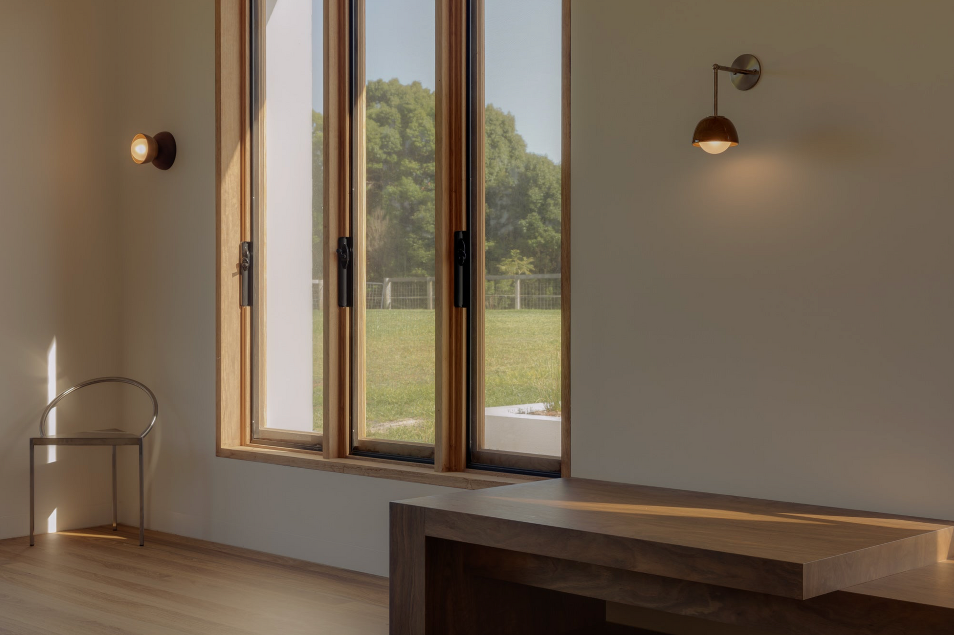 Modern interior with large windows, a chair, and a desk.