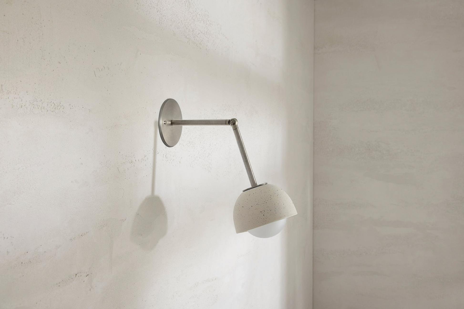 Wall-mounted lamp with a ceramic shade on a light grey wall