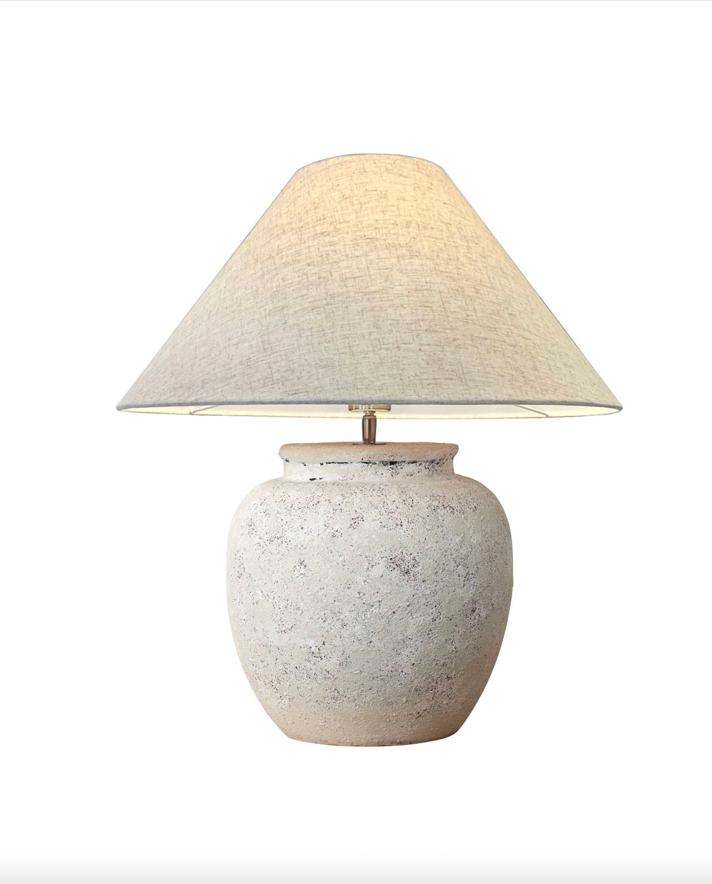 Table lamp with textured white base and beige lampshade on a white background