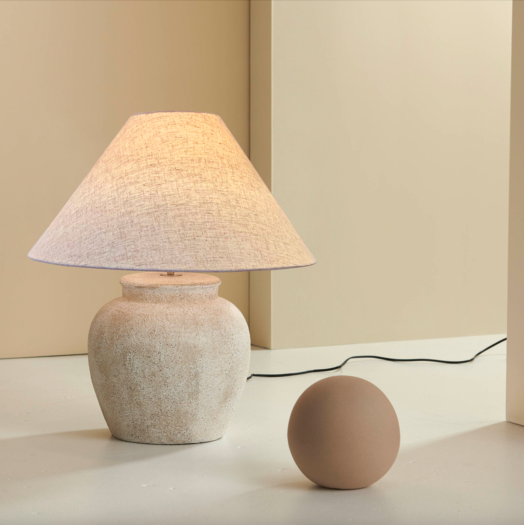Beige table lamp with textured shade on a neutral background