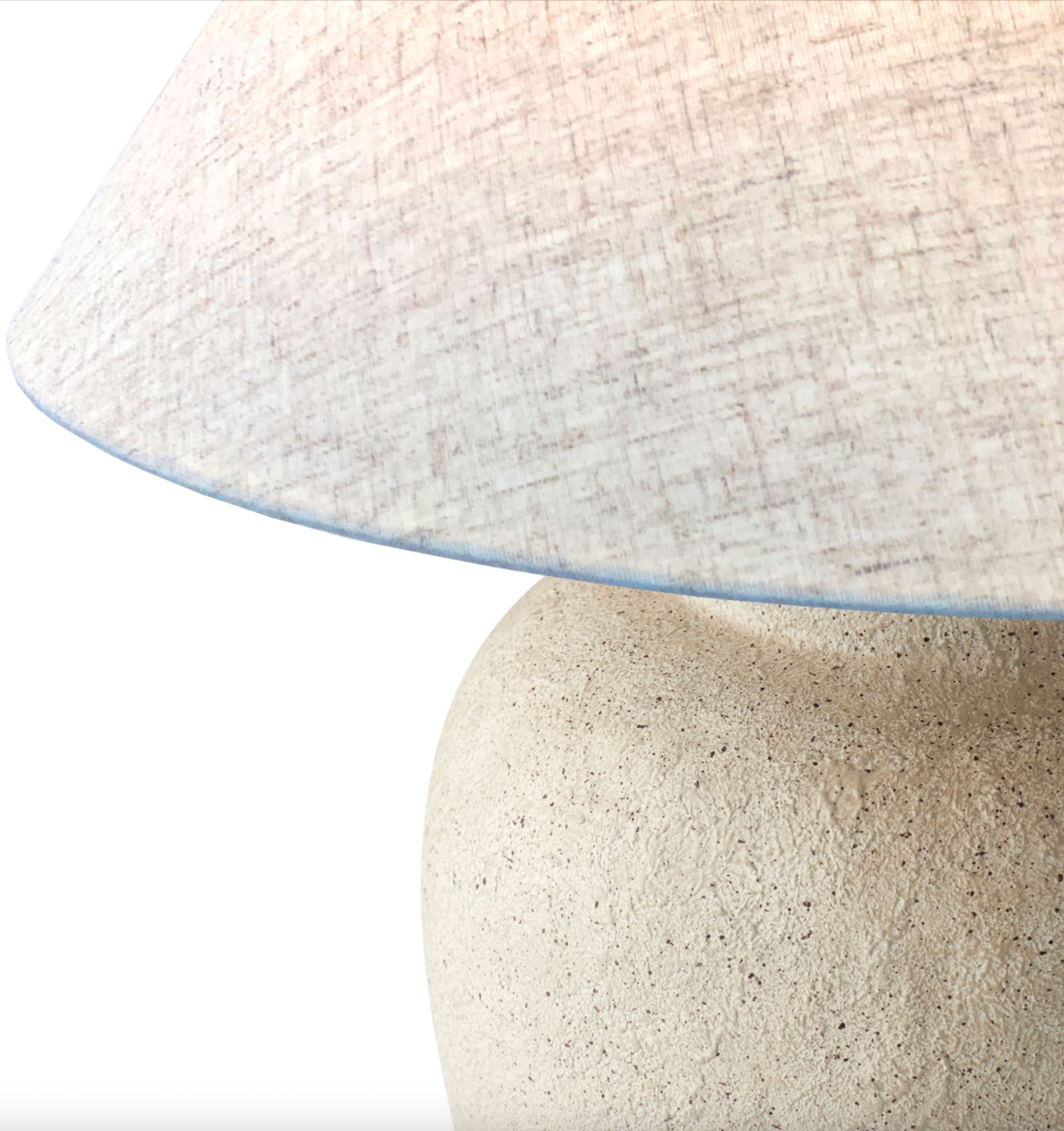 Close-up of a lamp with a textured white shade and stone-like base.