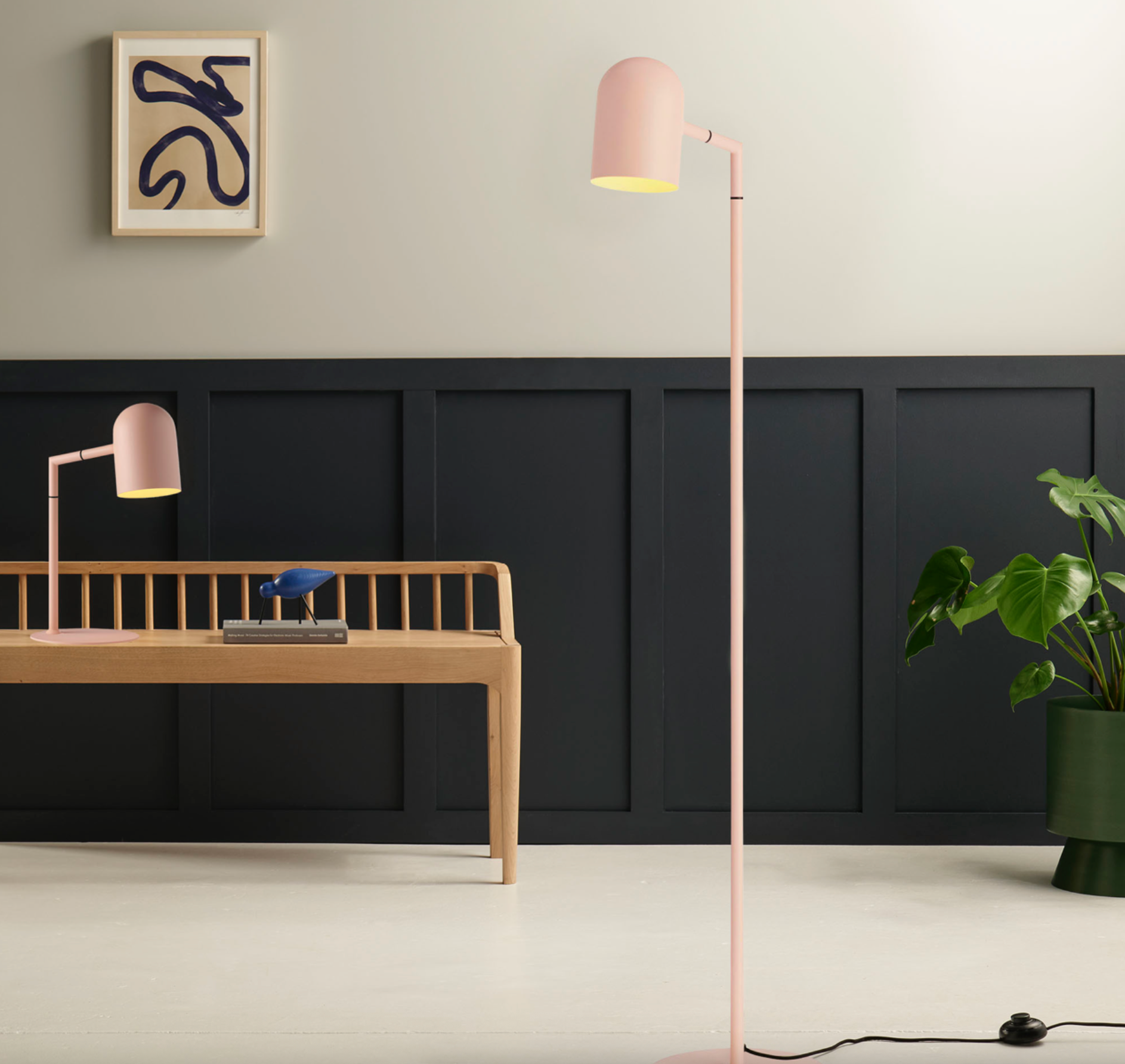 Modern interior with a desk, floor lamp, and wall art.