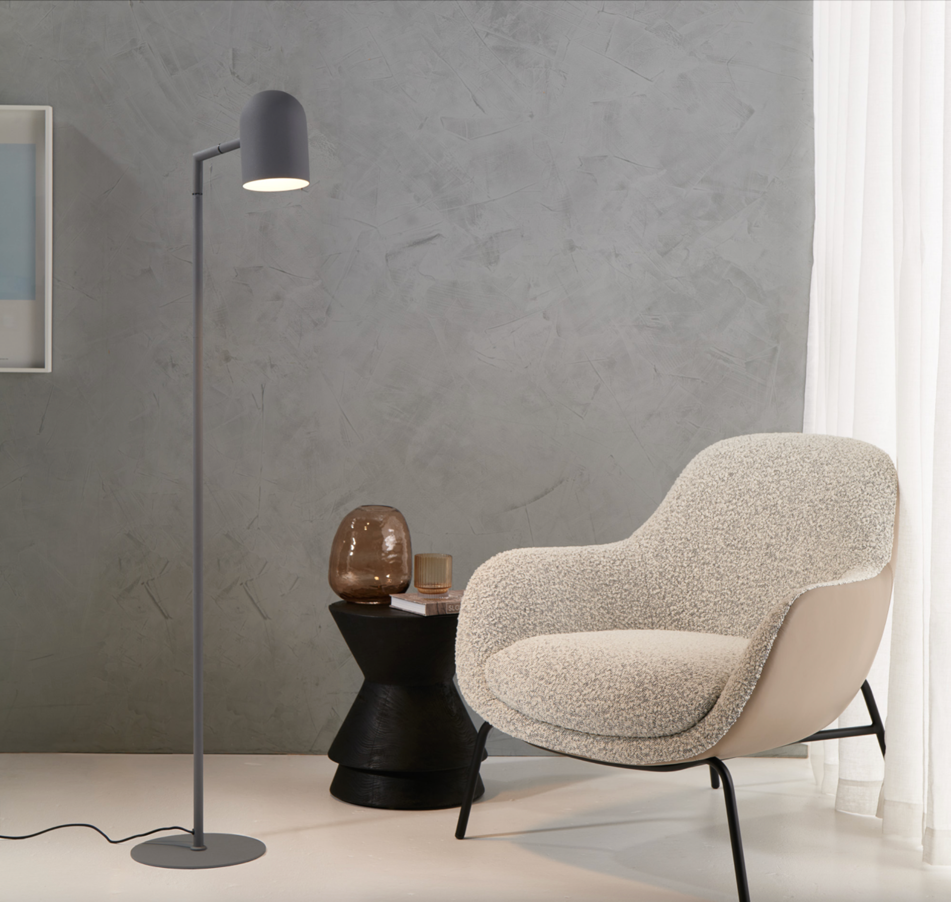 Modern chair and floor lamp in a minimalistic room with gray wall and white floor.