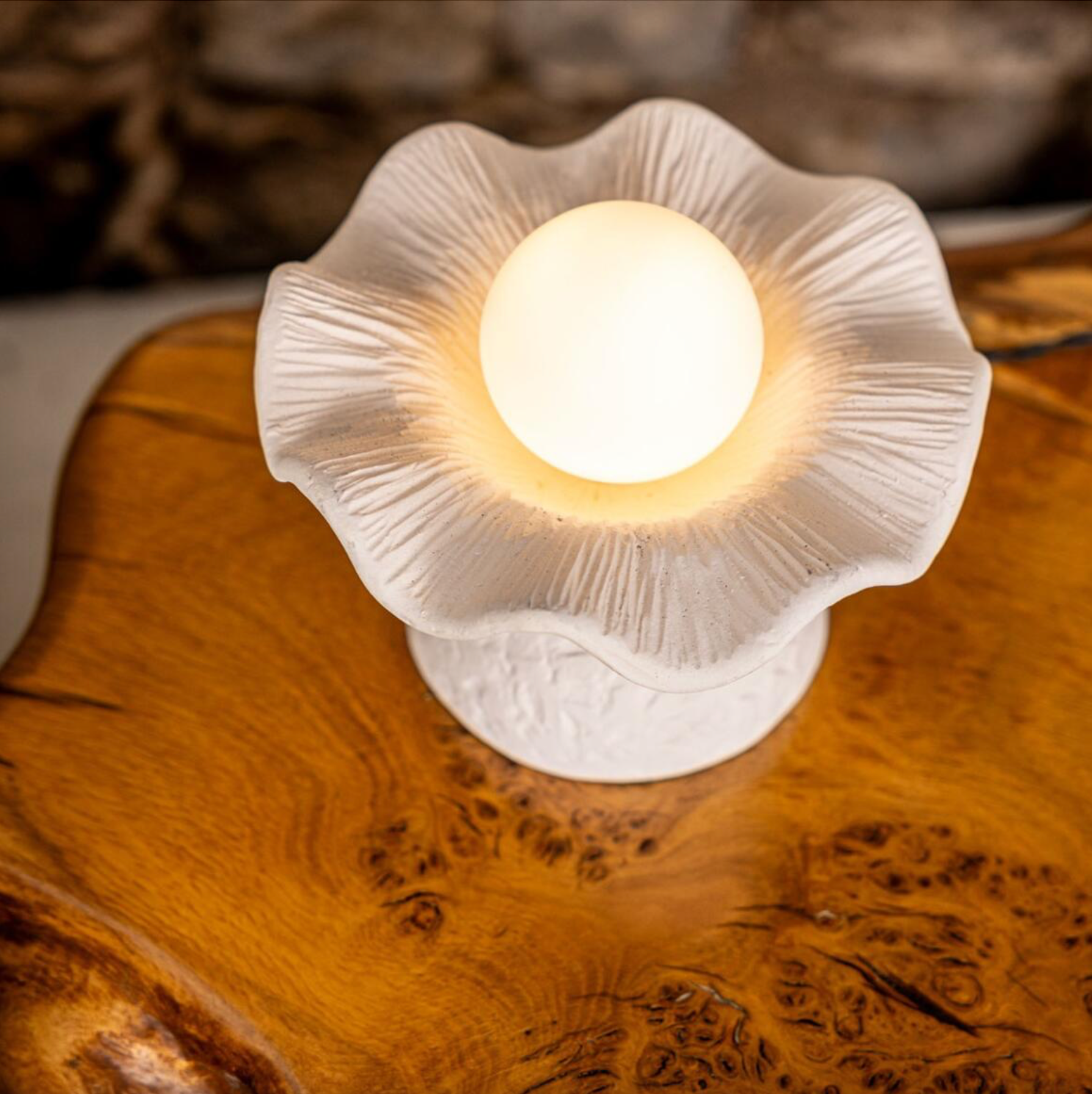 White ceramic lamp with a textured design on a wooden surface