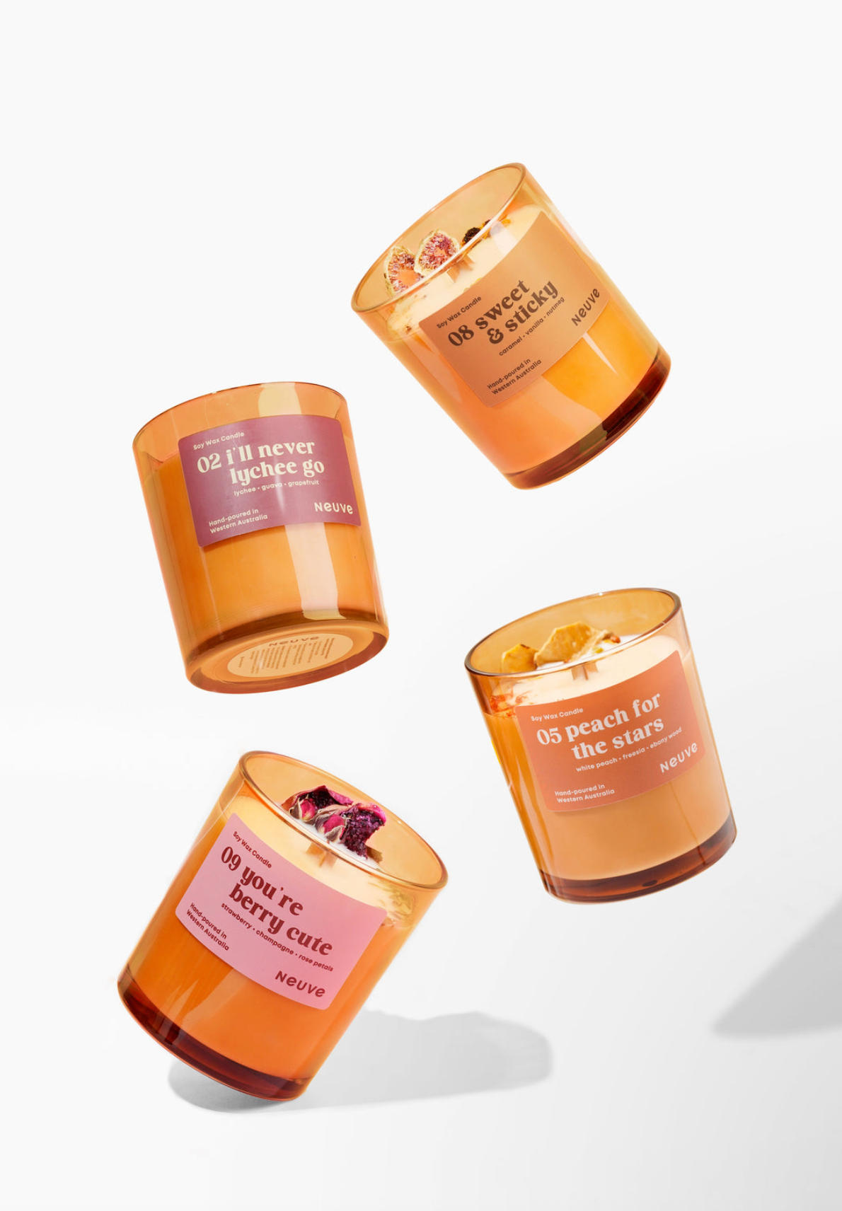 Four scented candles with visible labels on a white background