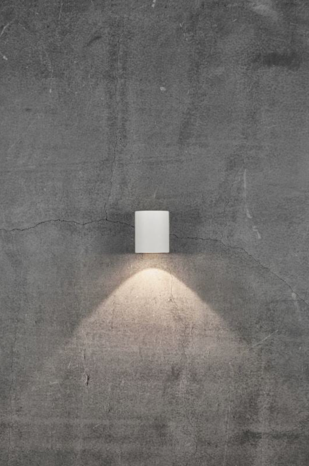 Modern outdoor wall light fixture on a textured concrete wall