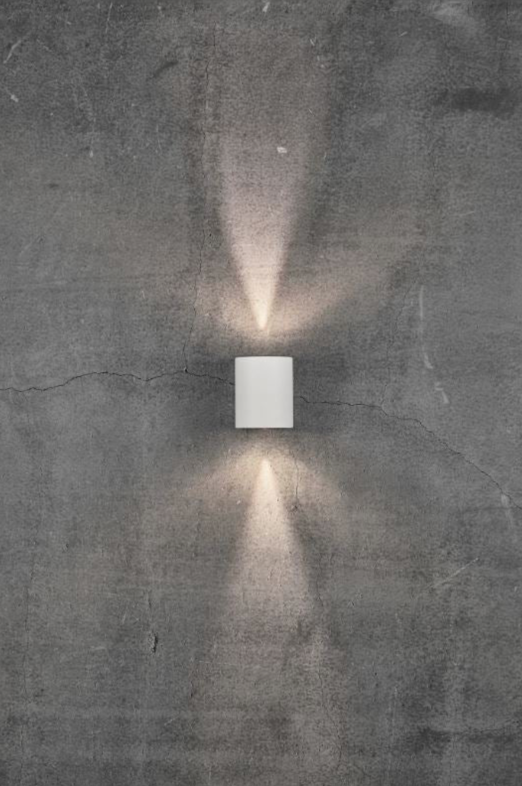 Modern wall-mounted light fixture on a textured concrete wall