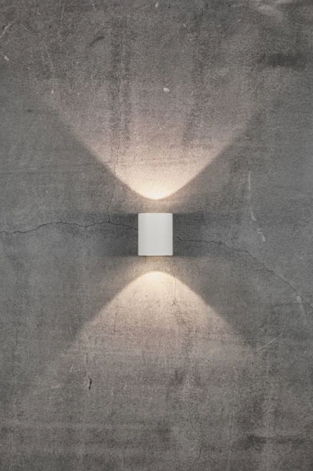 Modern wall-mounted light fixture on a textured concrete wall