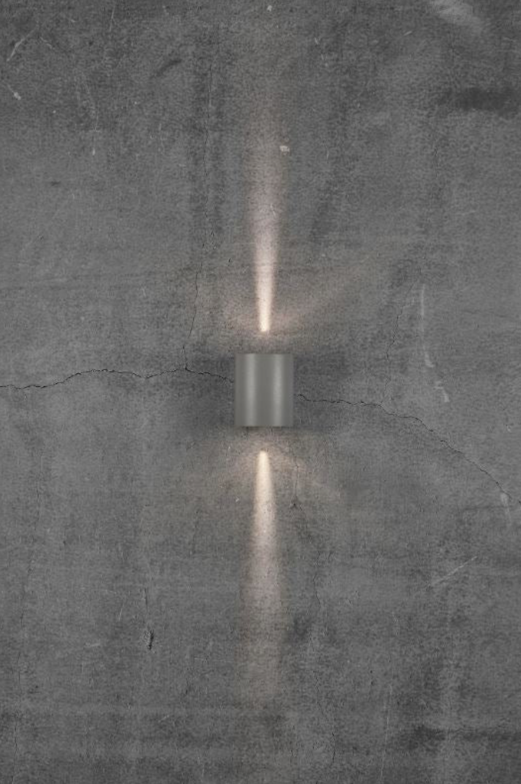 Wall-mounted outdoor light fixture on a textured grey wall