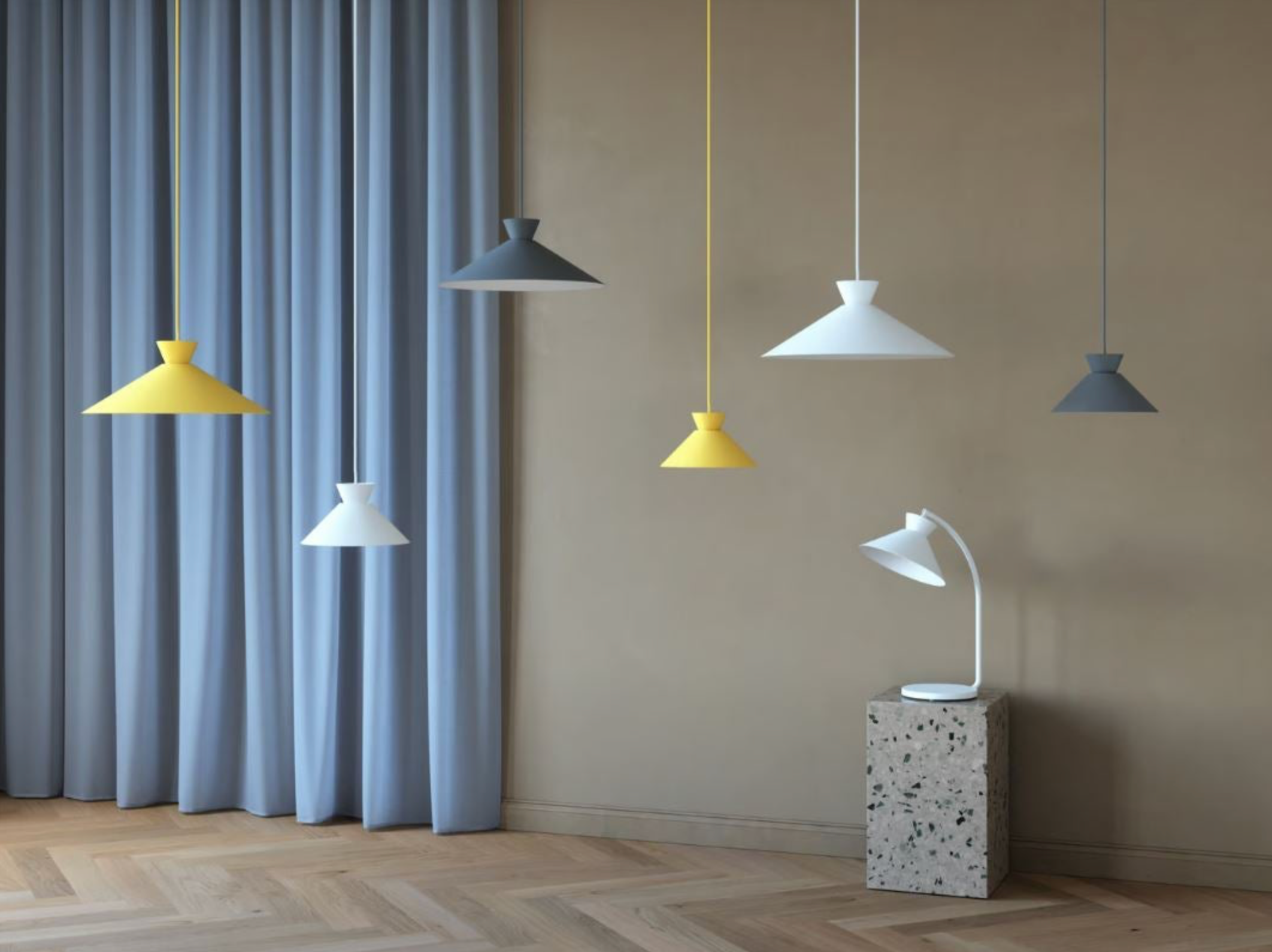Set of pendant lights in various colors hanging against a neutral wall with a curtain.