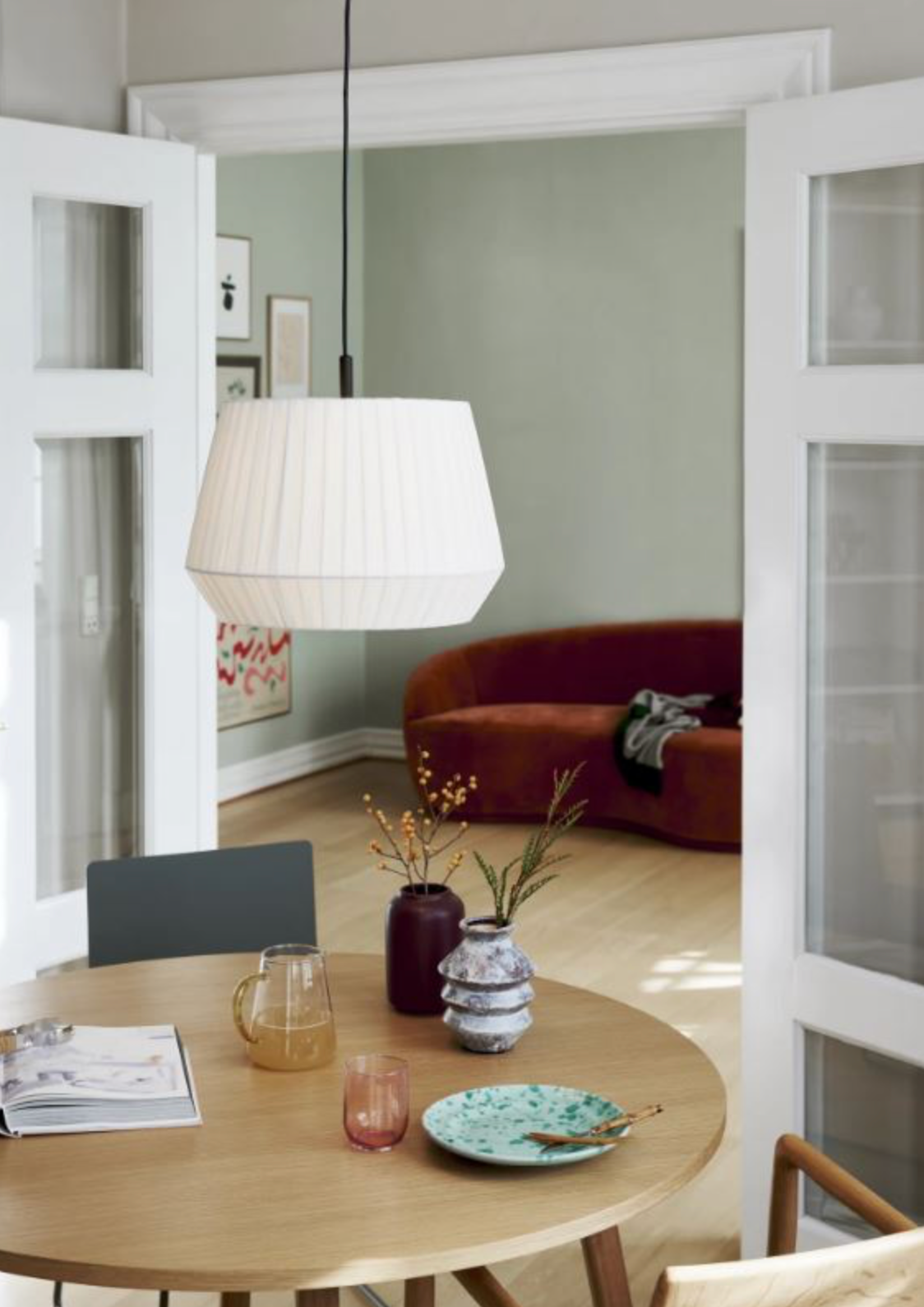 Modern interior with a round wooden table, chairs, and decorative items.