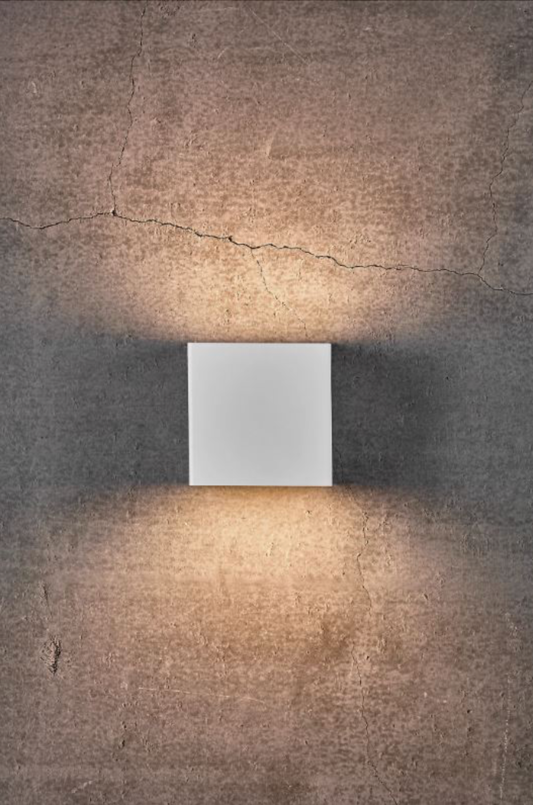 Square wall light fixture on a textured concrete wall