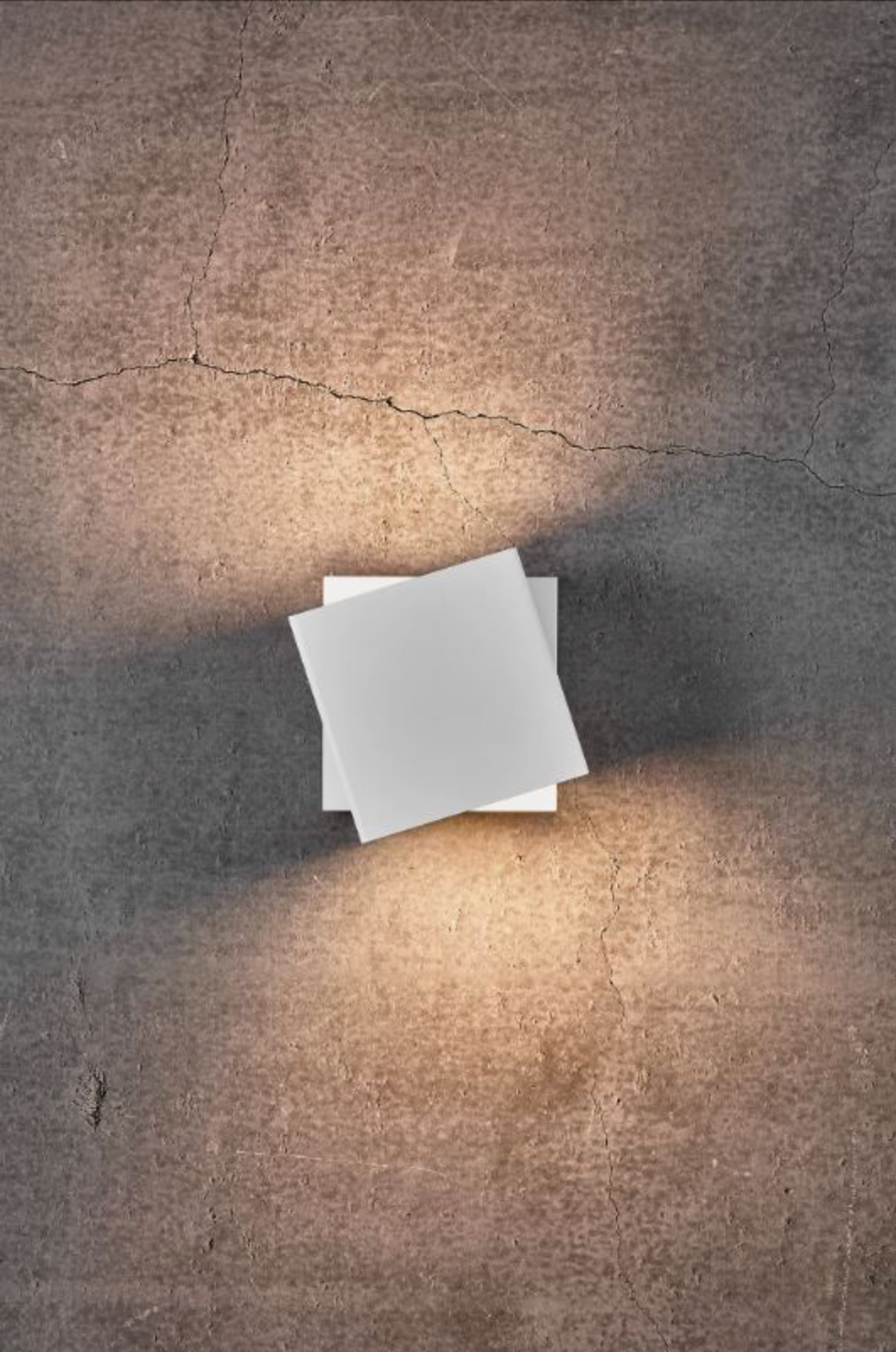White wall light on a textured concrete surface with a light source casting shadows.