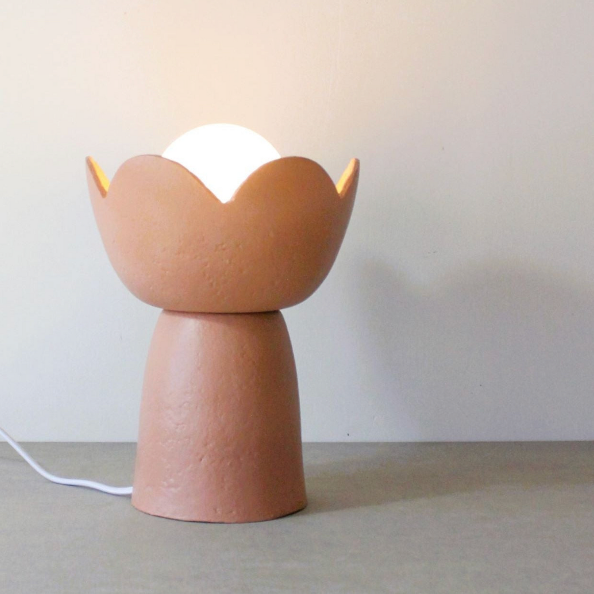 Hand made table lamp with a unique design on a plain background