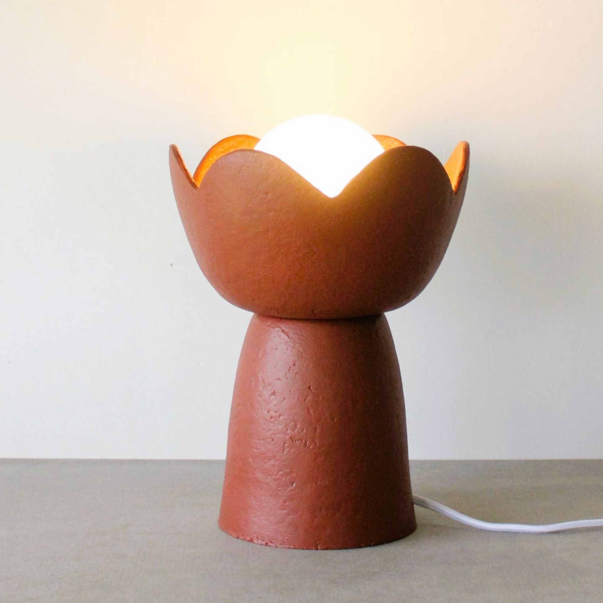 Ceramic table lamp with a unique design on a plain background