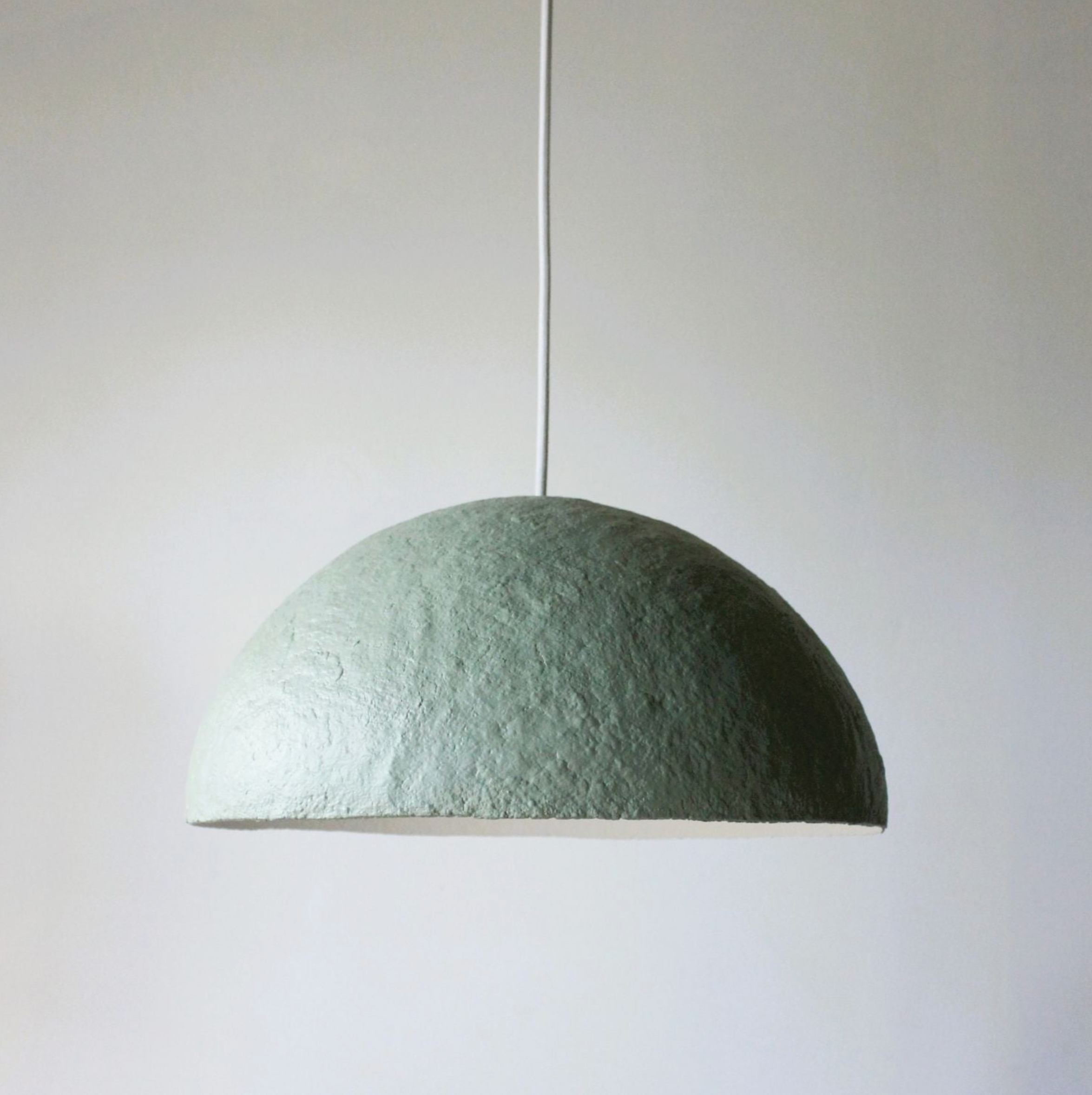 Green pendant lamp against a plain background