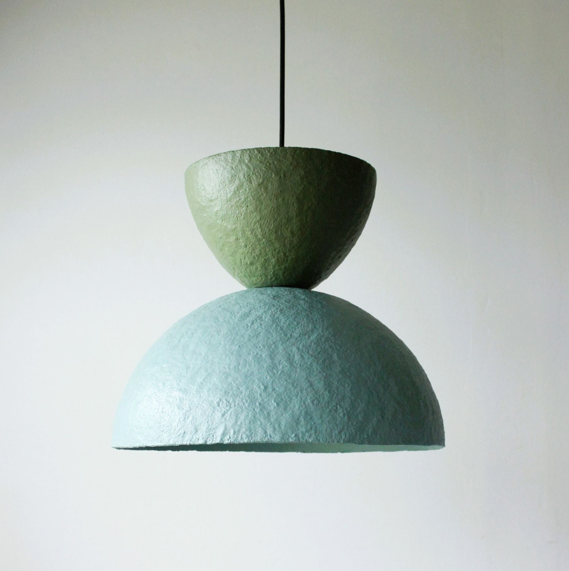 Green and blue pendant lamp on a plain background