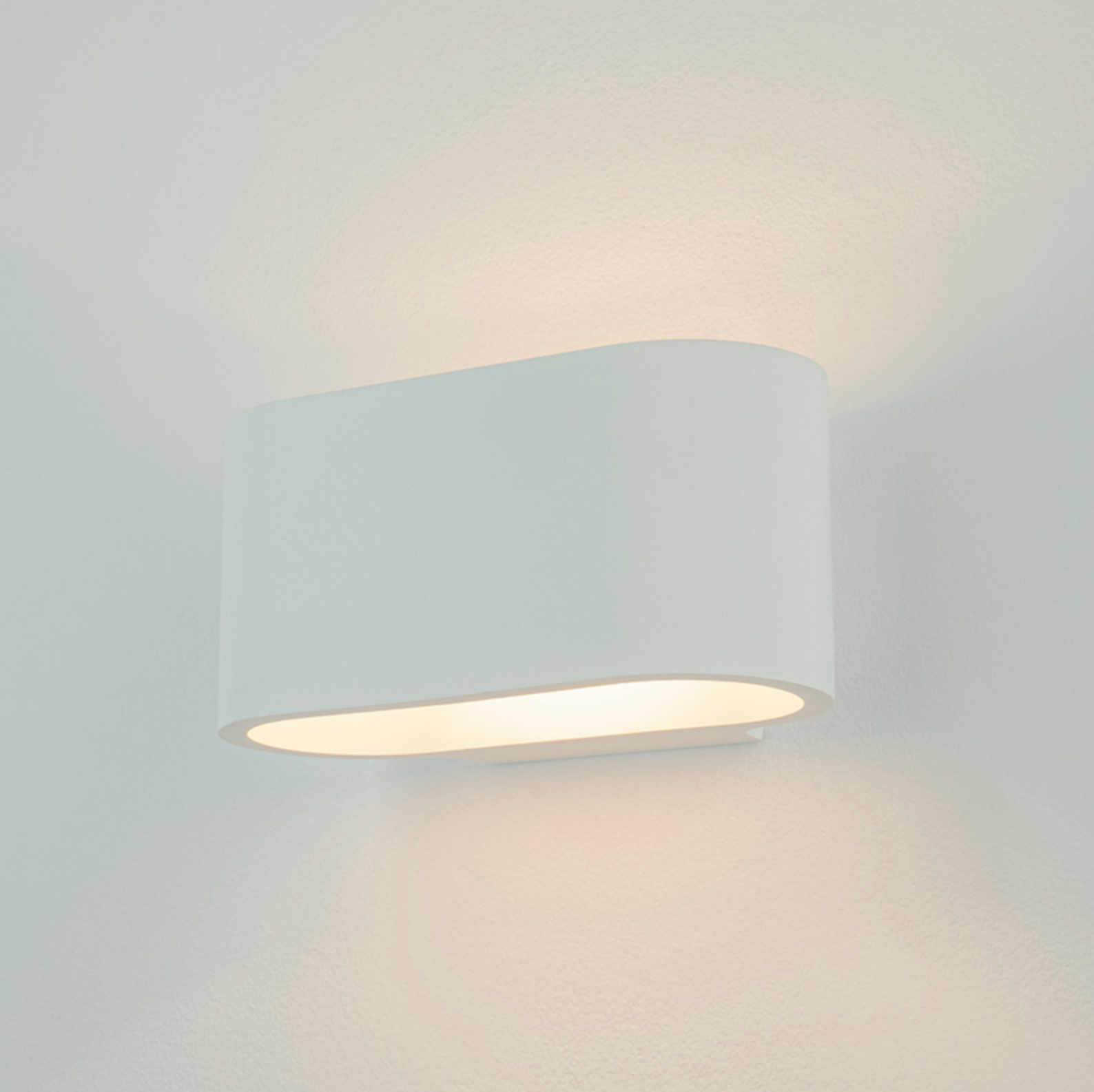 White wall-mounted light fixture on a light grey background