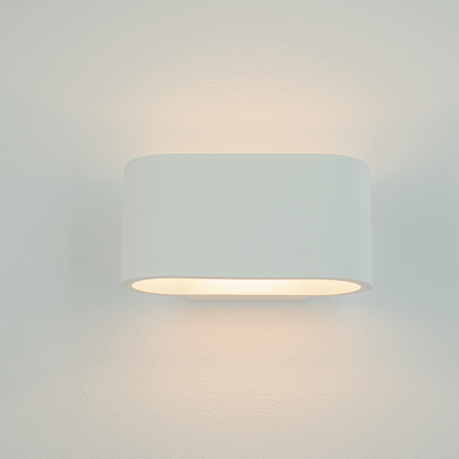 Curved white wall light fixture on a plain background