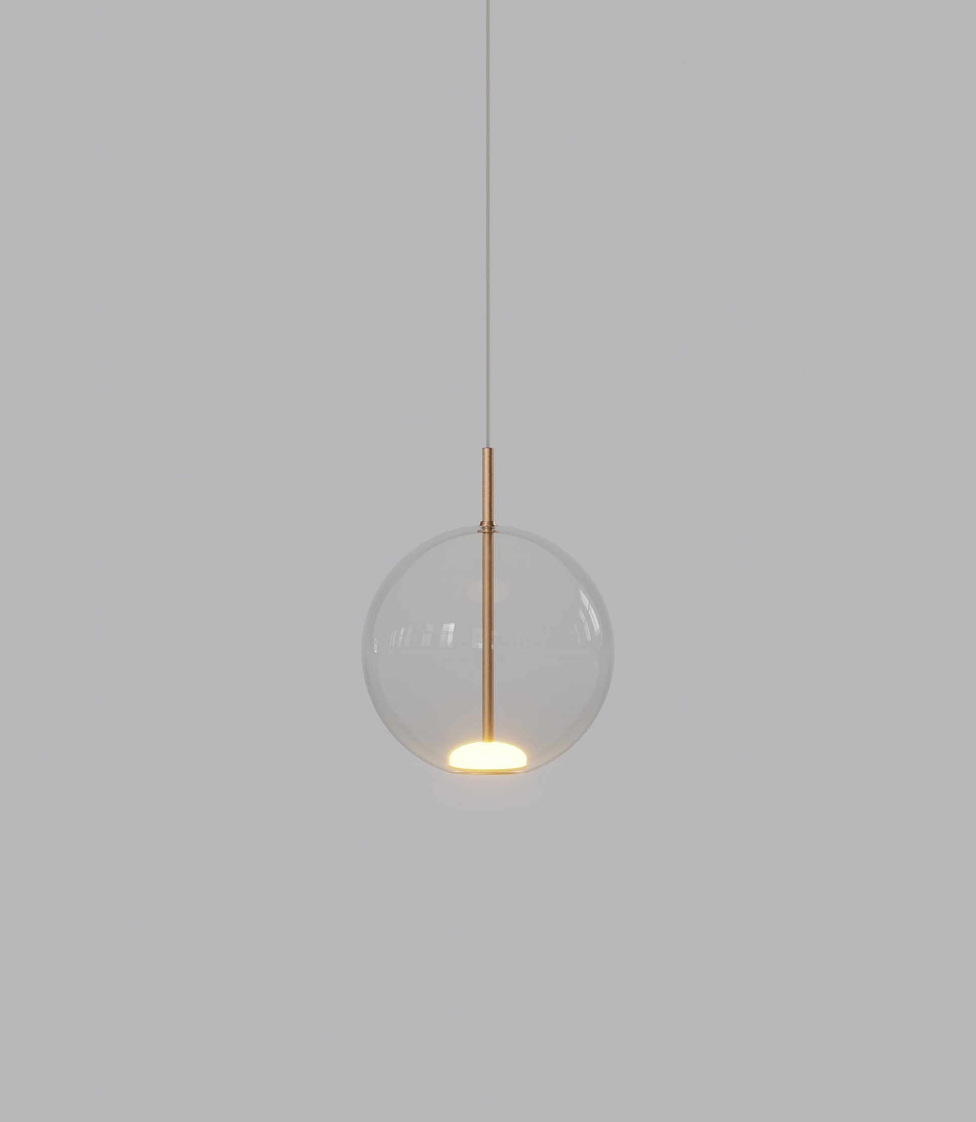 Pendant light with clear glass shade and gold fixture on a grey background