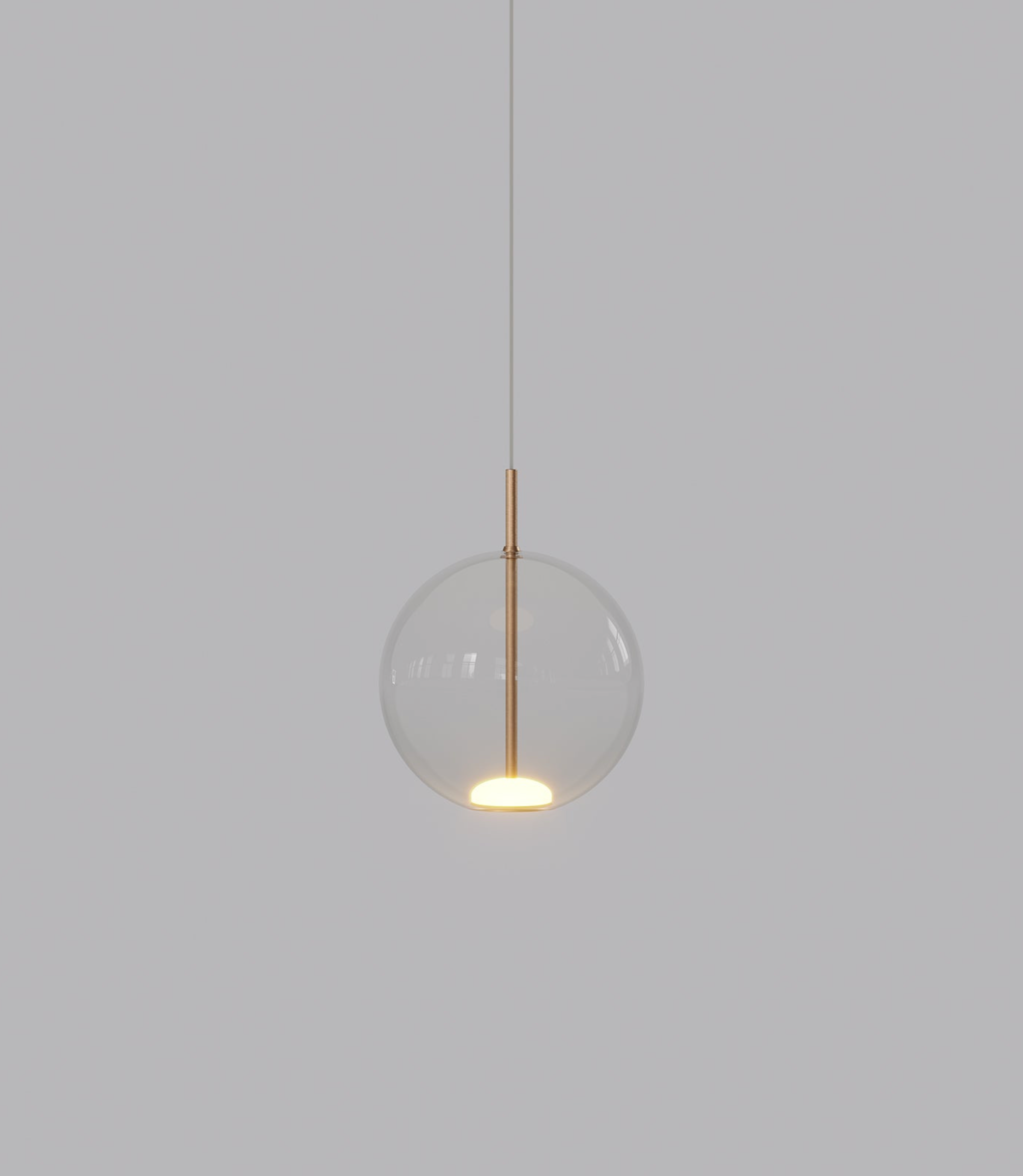 Pendant light with clear glass shade and gold fixture on a grey background