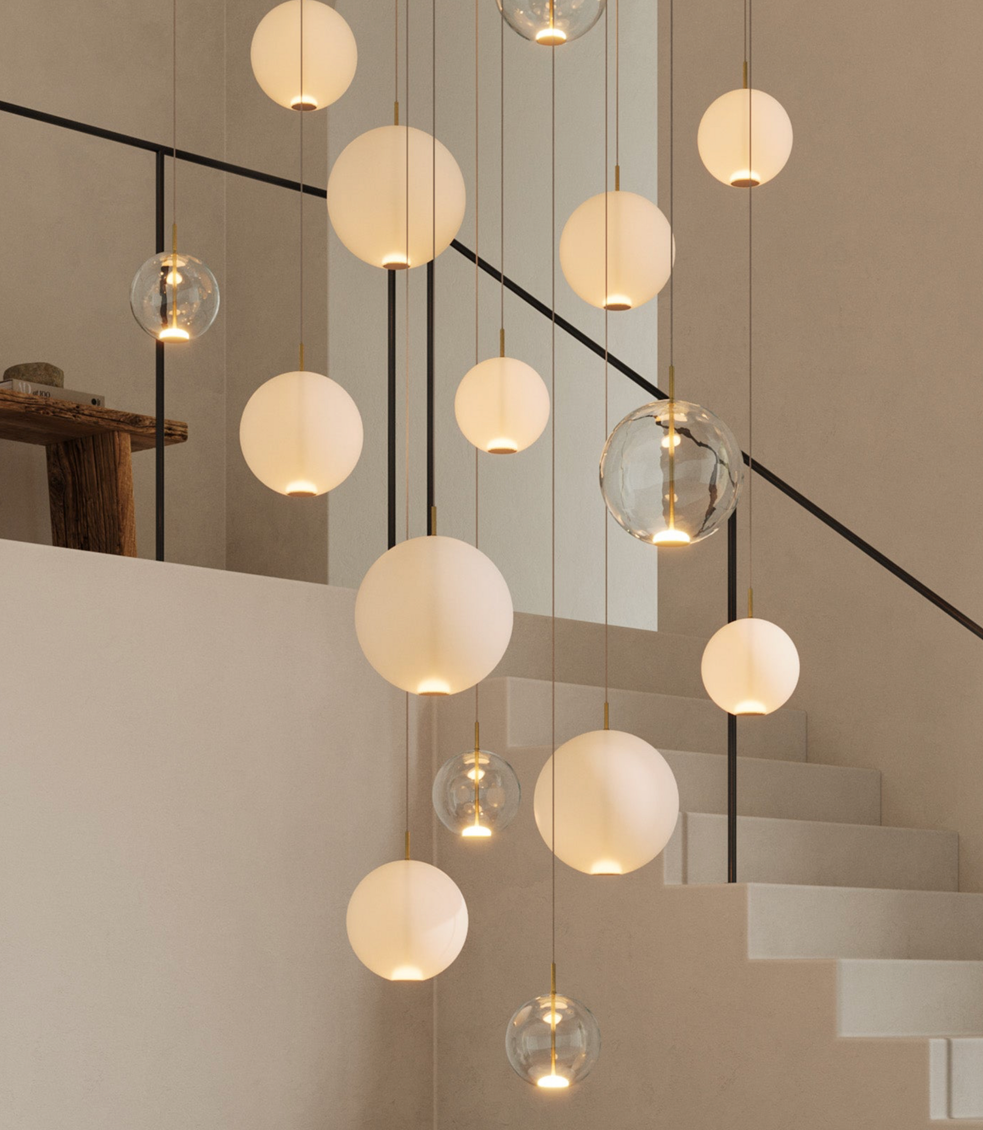 Cluster of modern glass pendant lights hanging in a room with a staircase