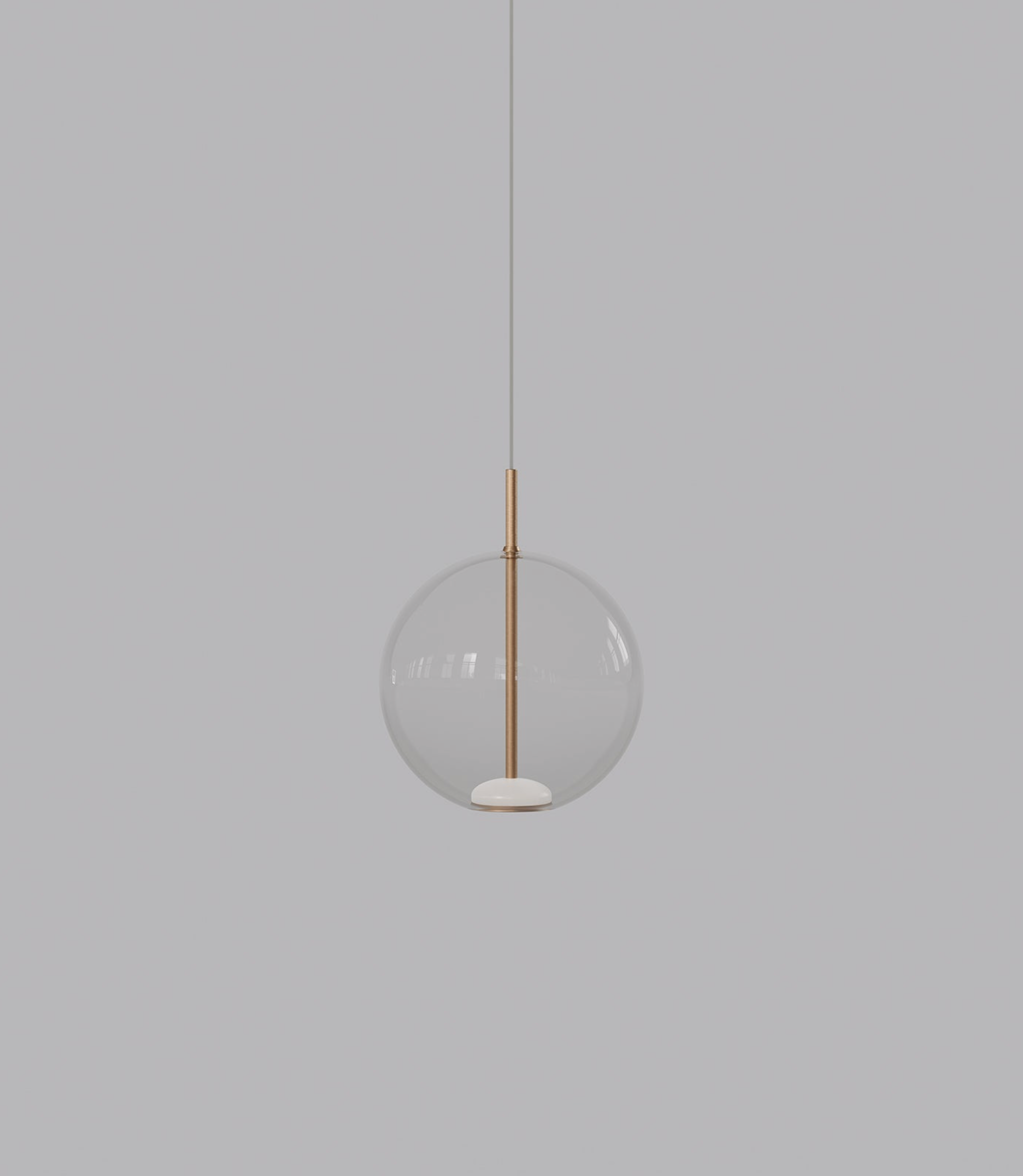 Spherical pendant light with a clear glass shade and brass fixture on a grey background