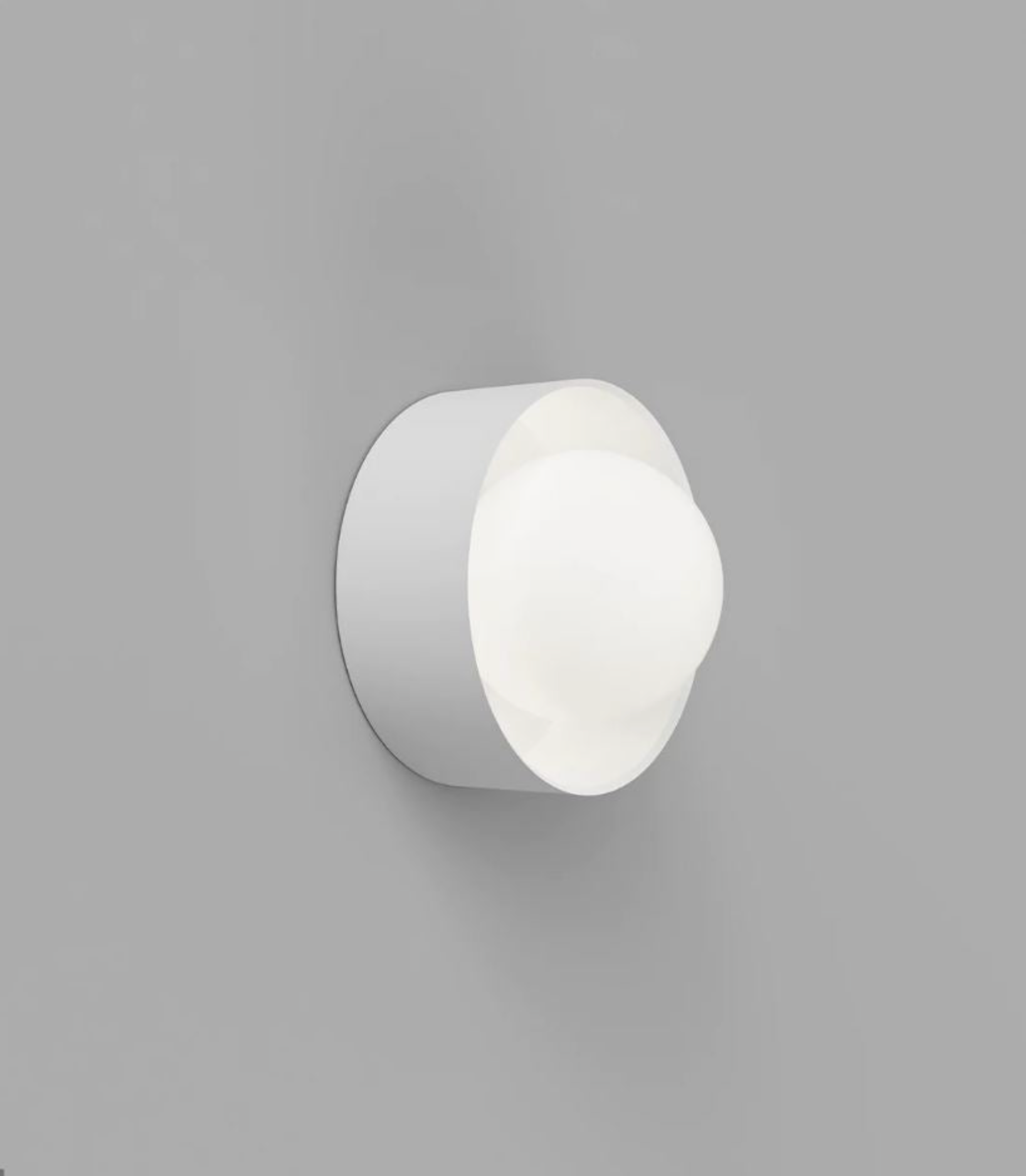 White wall-mounted light fixture on a gray background