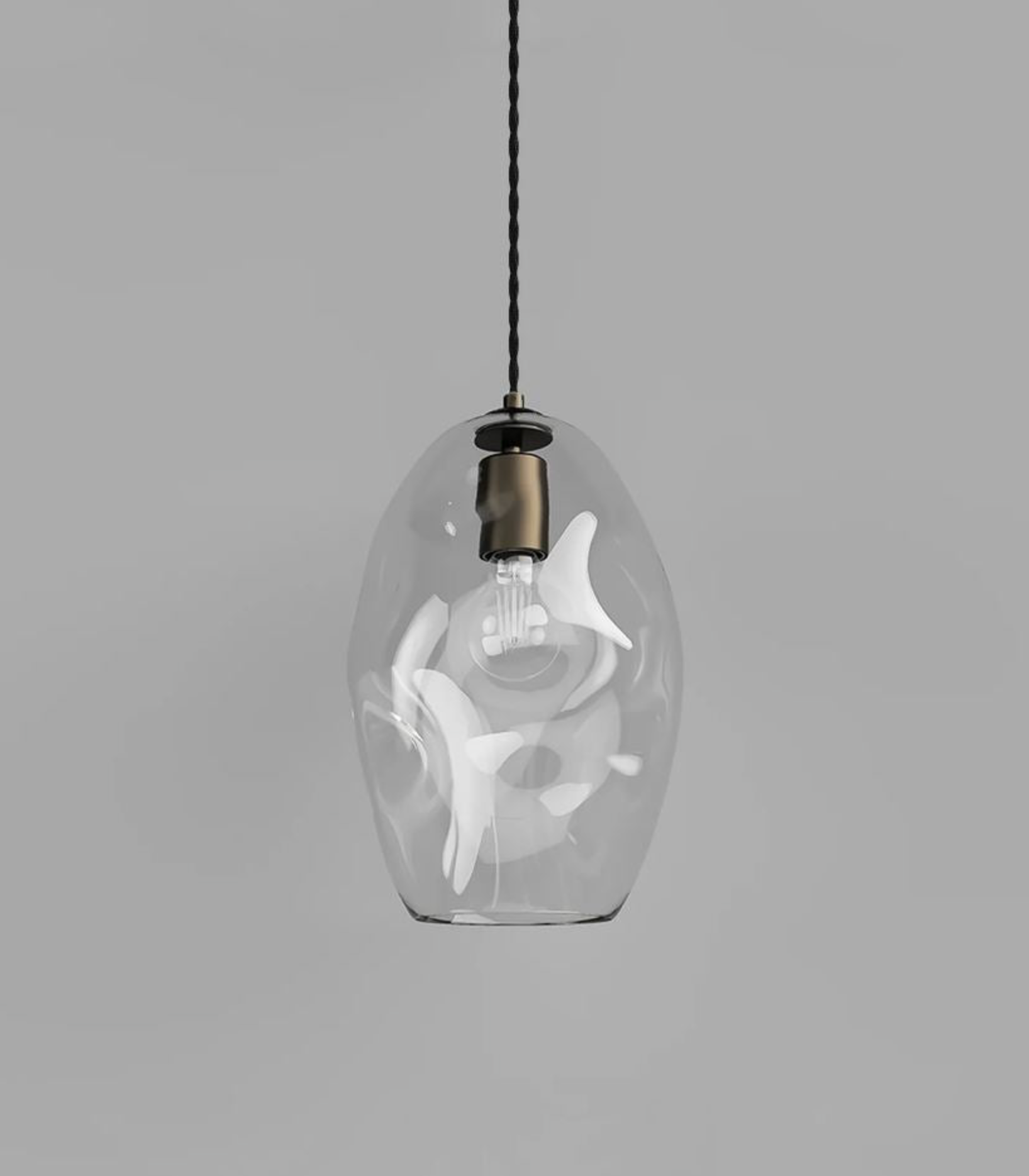 Clear glass pendant light with white interior on a gray background