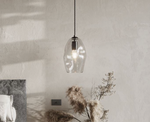Clear glass pendant light hanging in a room with minimal decor.
