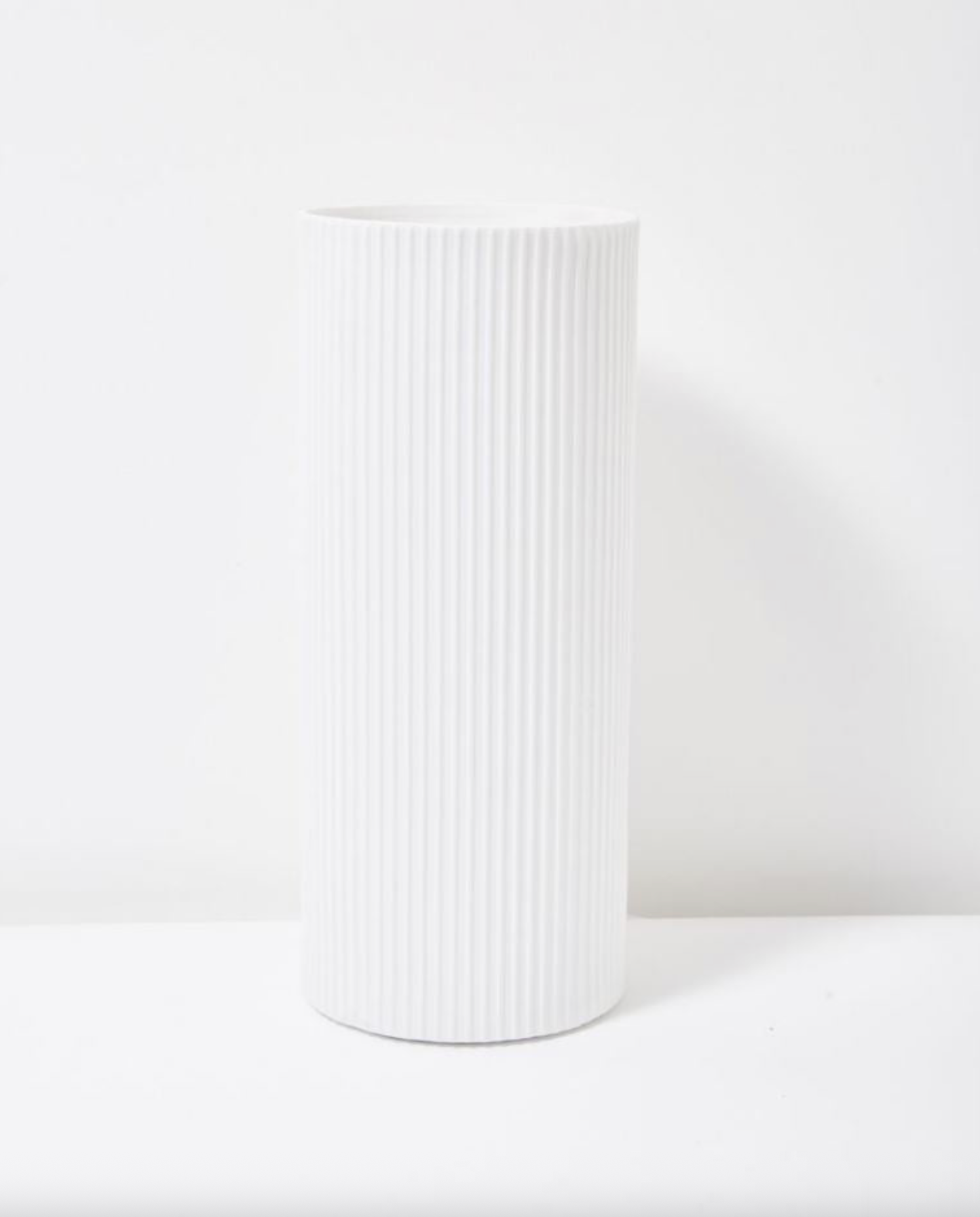 White ribbed table lamp on a white background