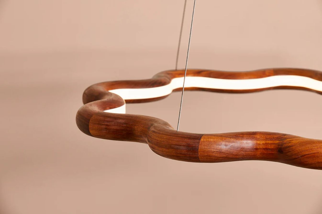 Wooden pendant light with a modern wave design on a beige background