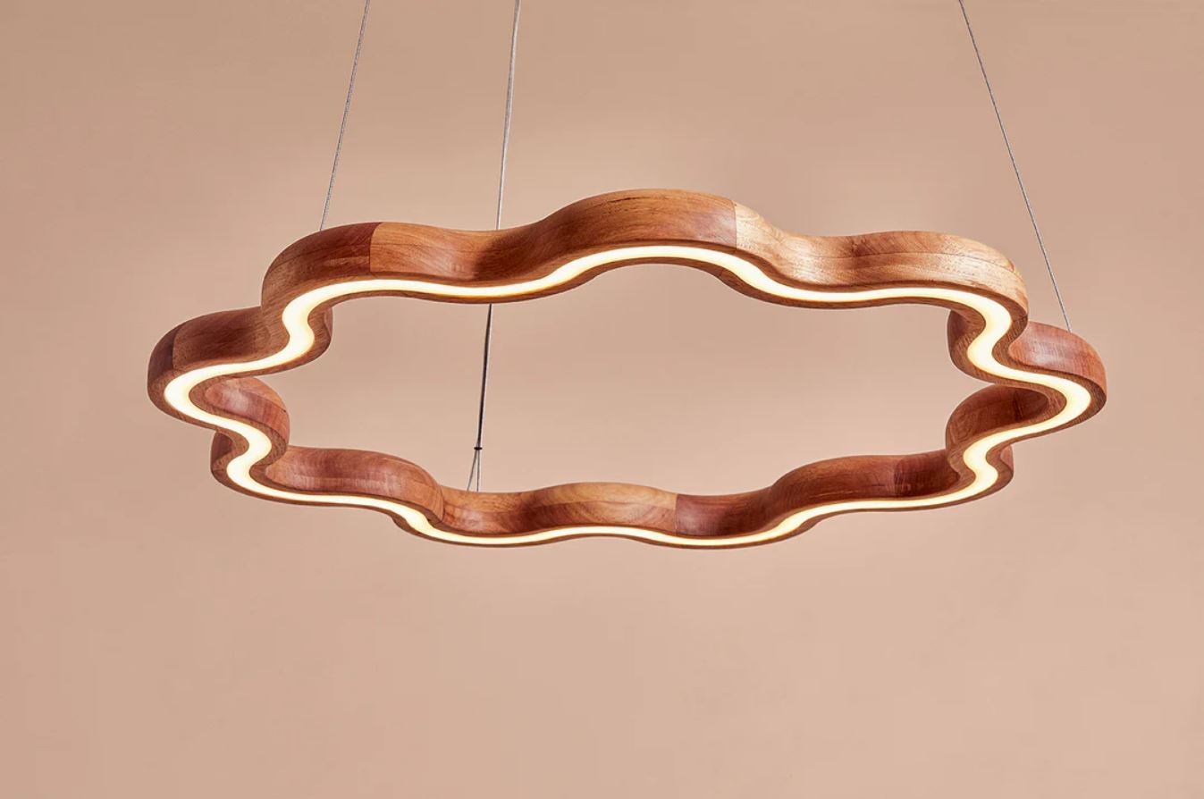Wooden pendant light with wavy design on a beige background